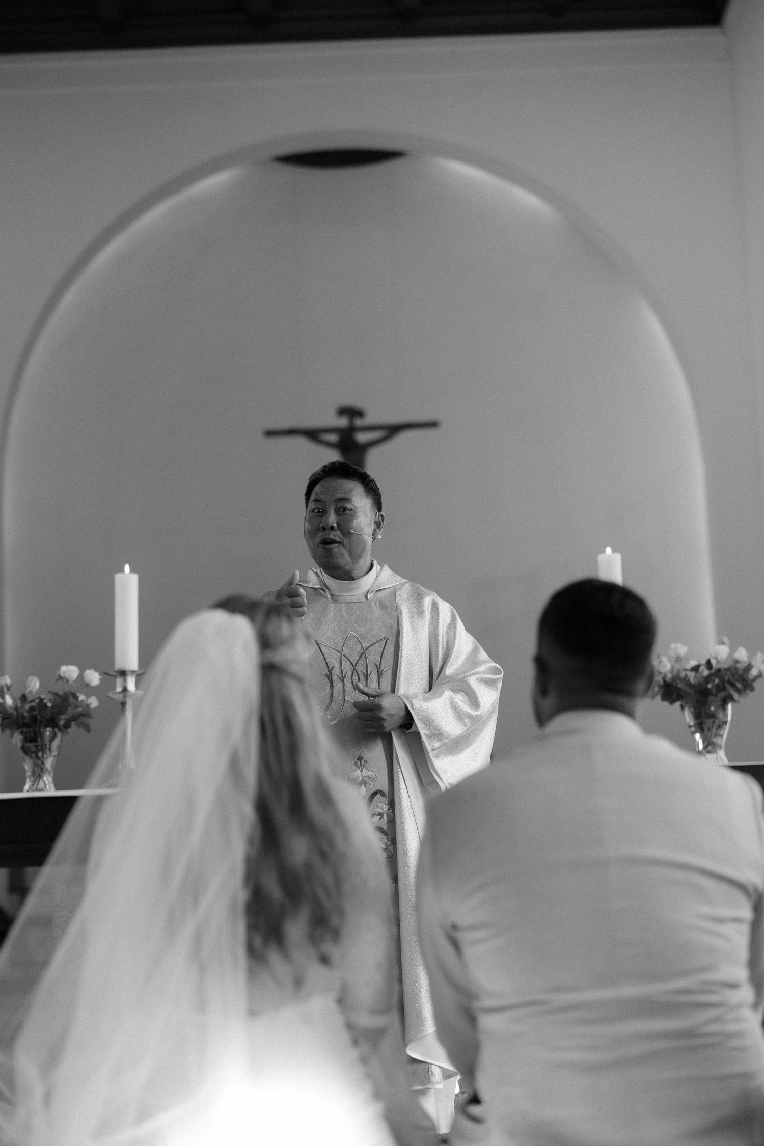 Religious ceremony in a church with white-robed clergy and attendees.