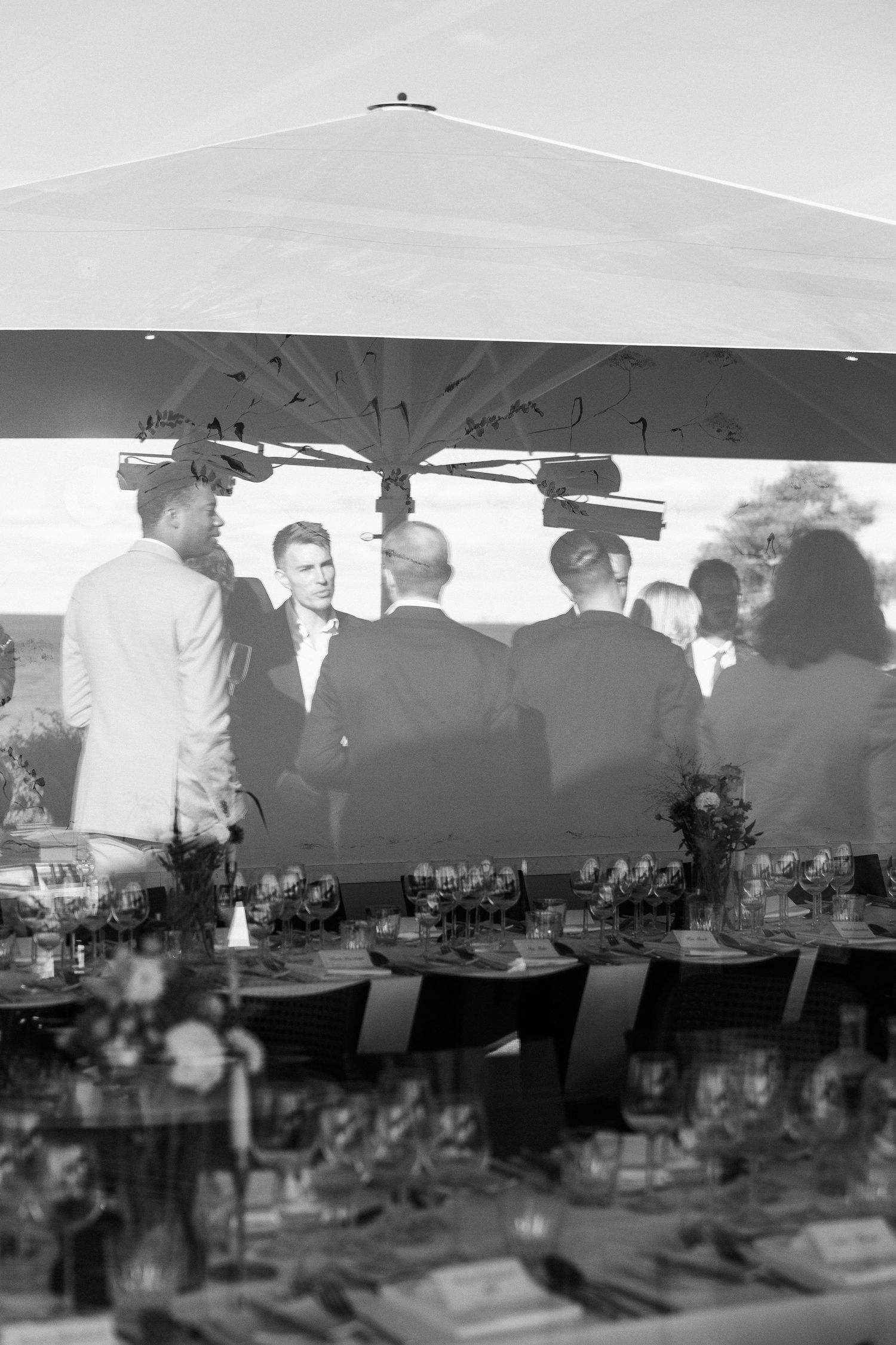 Reception tent setup with tables and chairs under billowing white canopy.