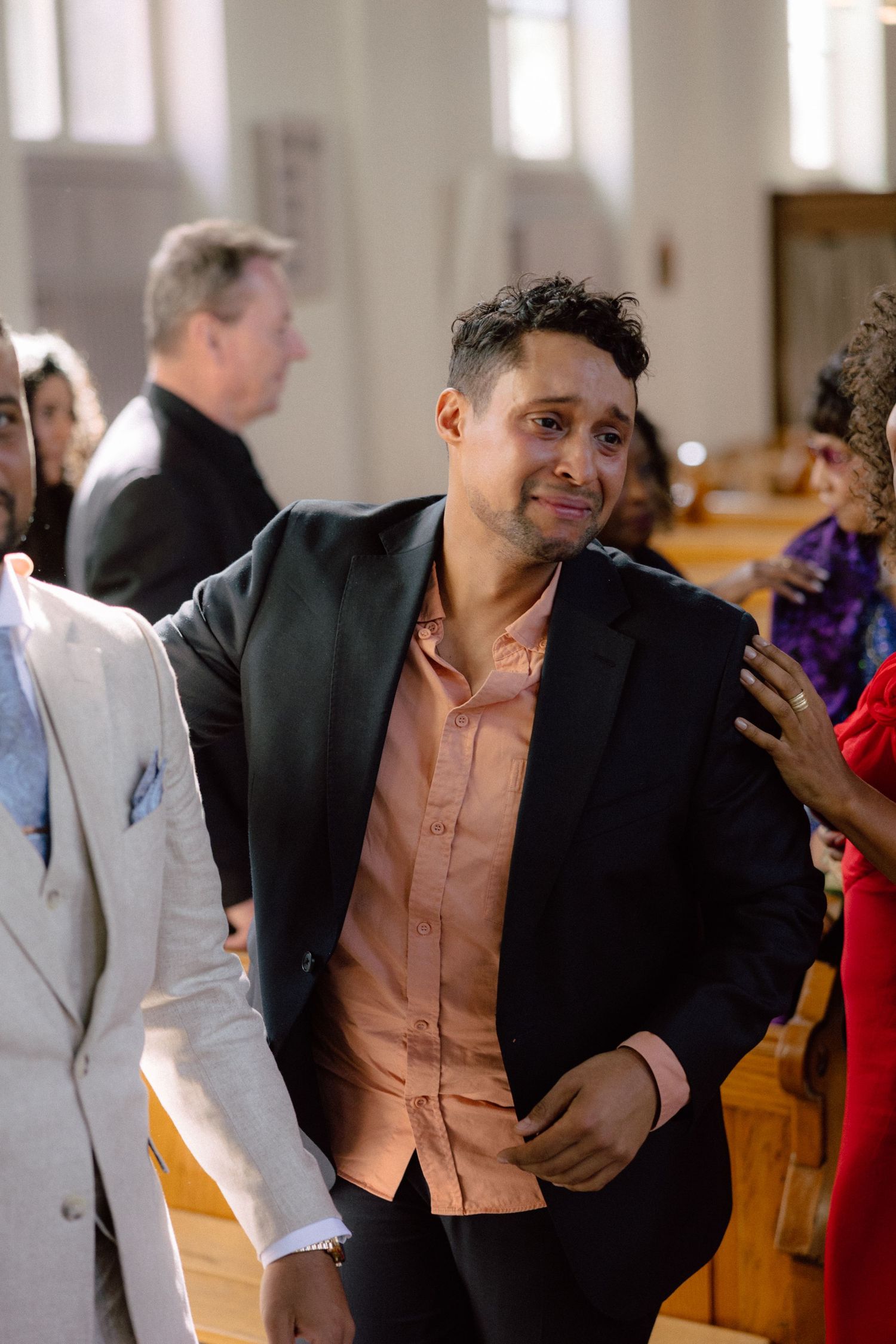 Wedding guests mingling and chatting inside an elegant church venue.