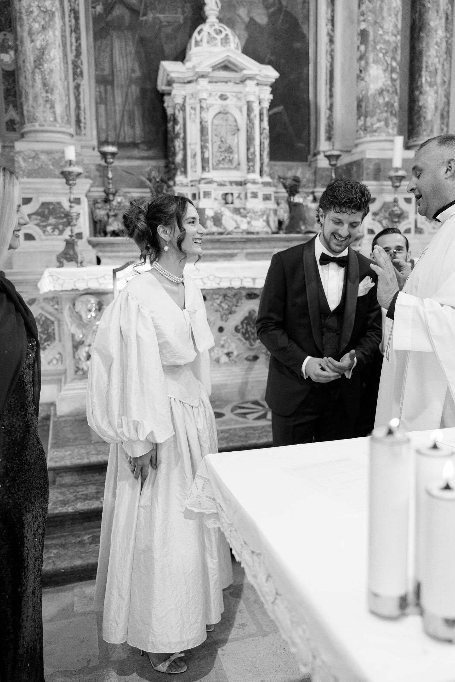 Wedding preparations inside an ornate church with altar servers in white robes.