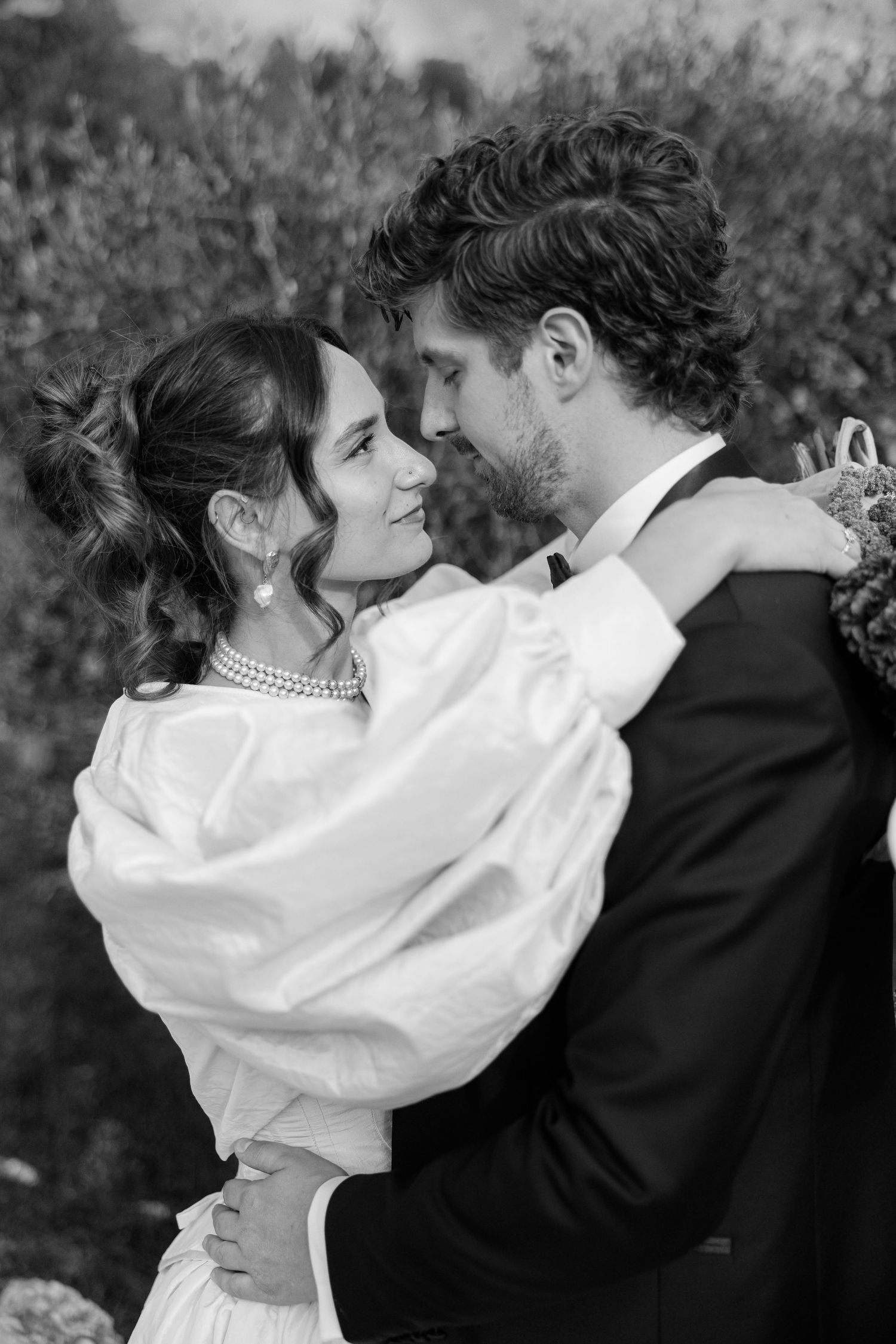 Romantic black and white wedding portrait showing tender embrace.