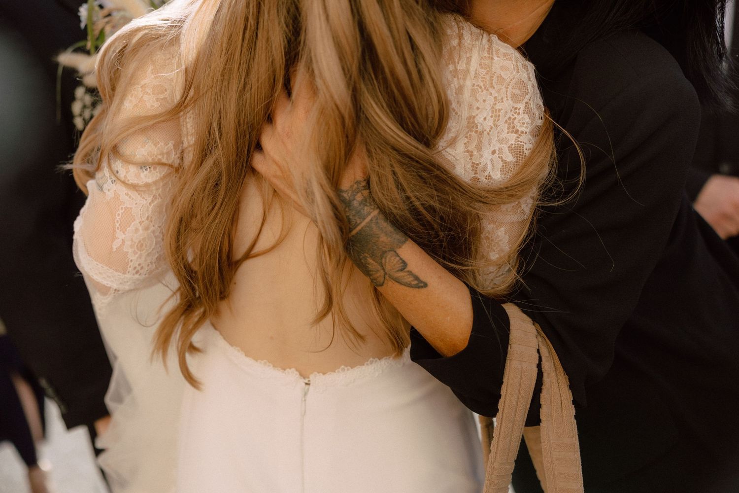 Close-up detail of back of wedding dress showing lace and zipper details.