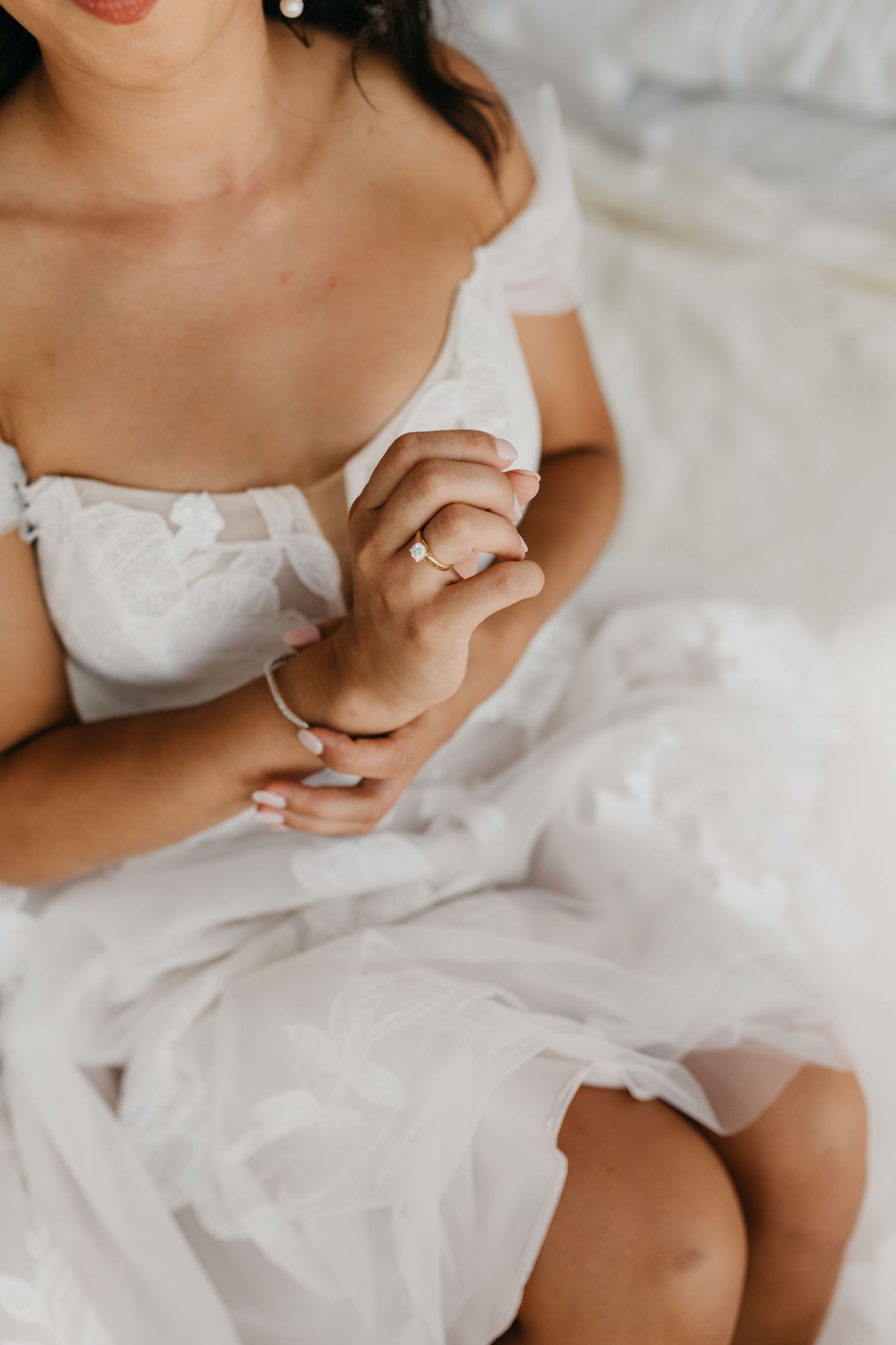 Detail shot of bride adjusting white lace dress.