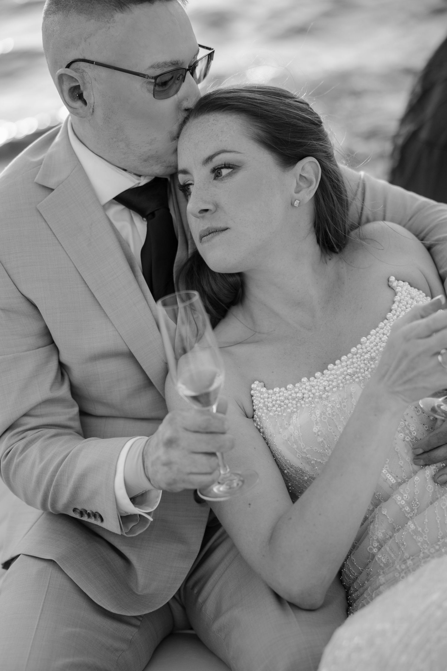 Intimate wedding portrait in black and white with champagne glasses.