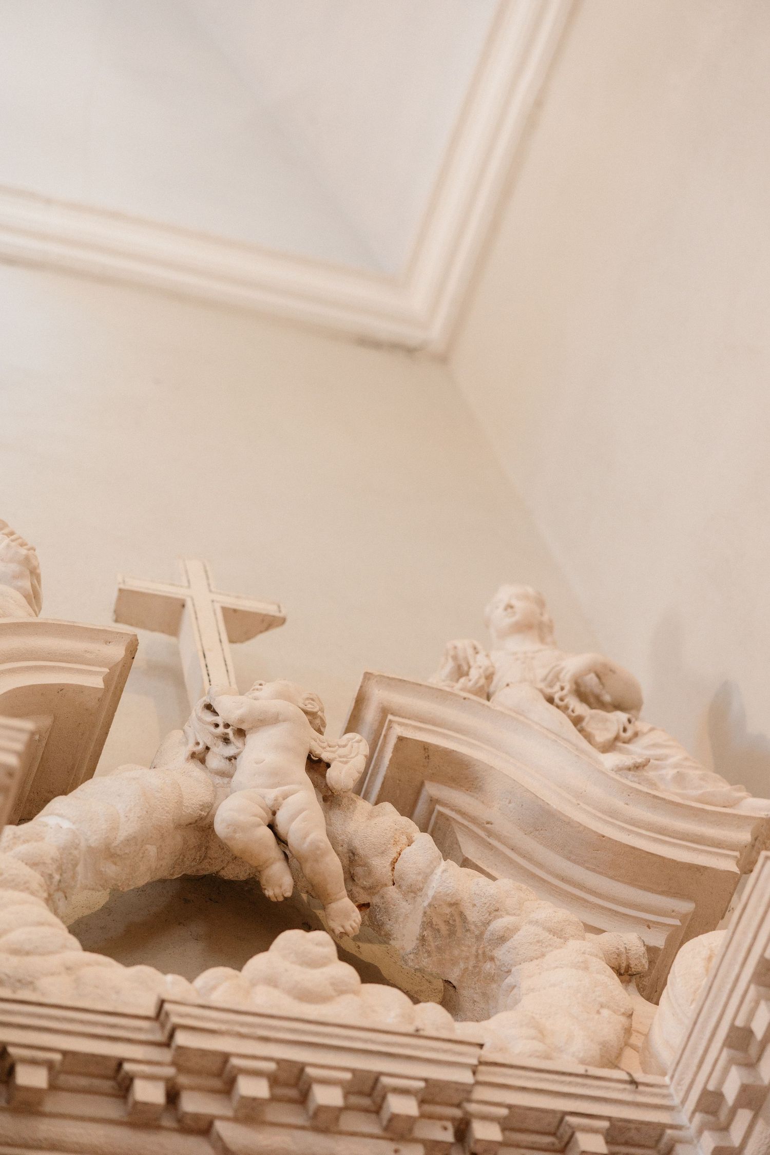 White marble sculptures displayed on ornate architectural pedestals in a classical setting.