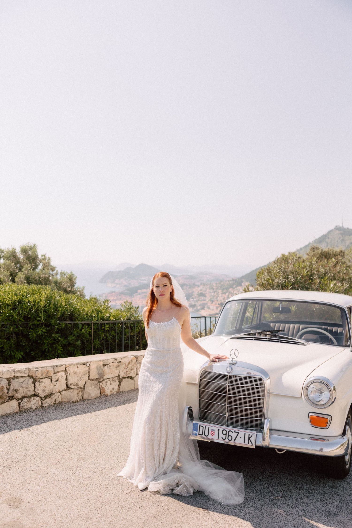 Classic white Mercedes-Benz parked on scenic mountain overlook.