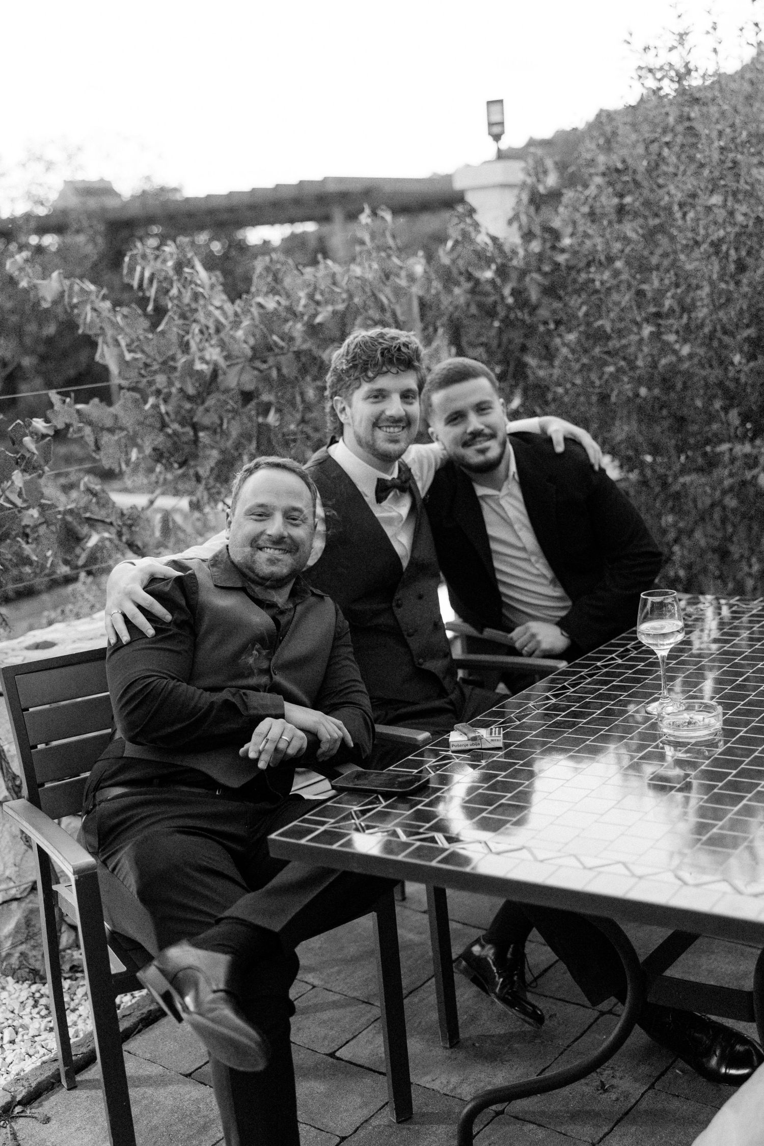 People relaxing at outdoor tables in black and white photography.