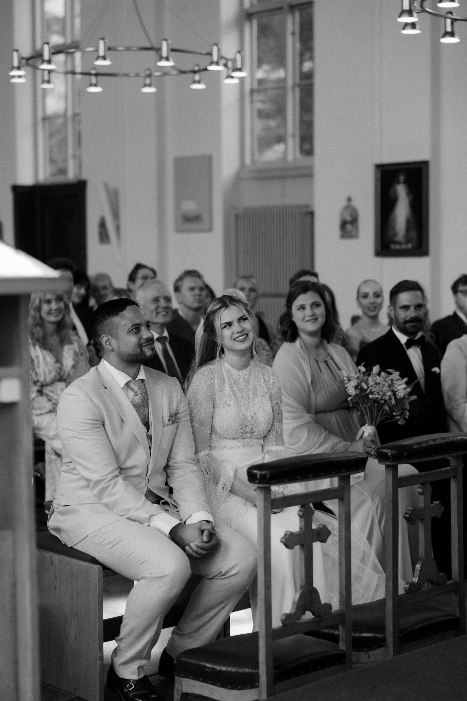 Wedding guests seated in church pews during a ceremony.