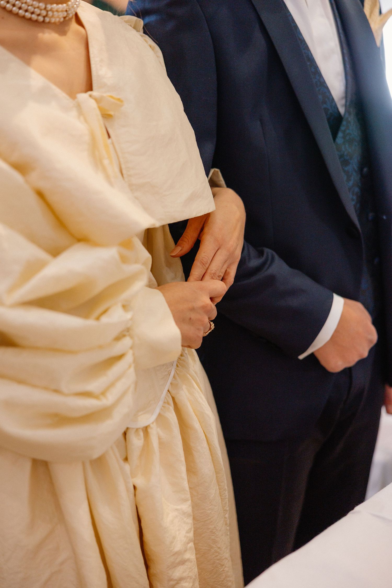 Elegant formal wear detail showing cream colored fabric against a navy suit.