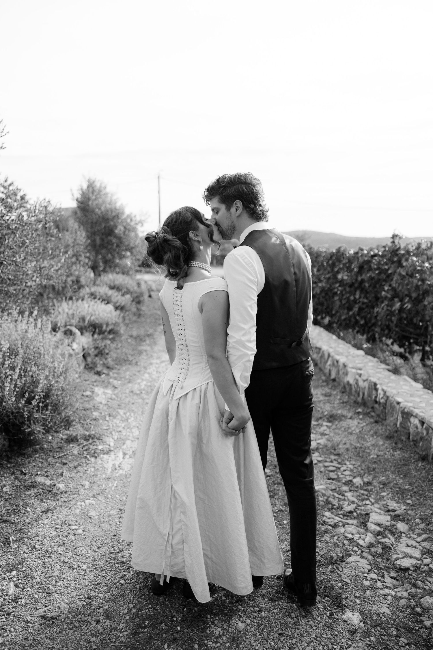 Black and white photo of a couple walking together through a rustic countryside path.