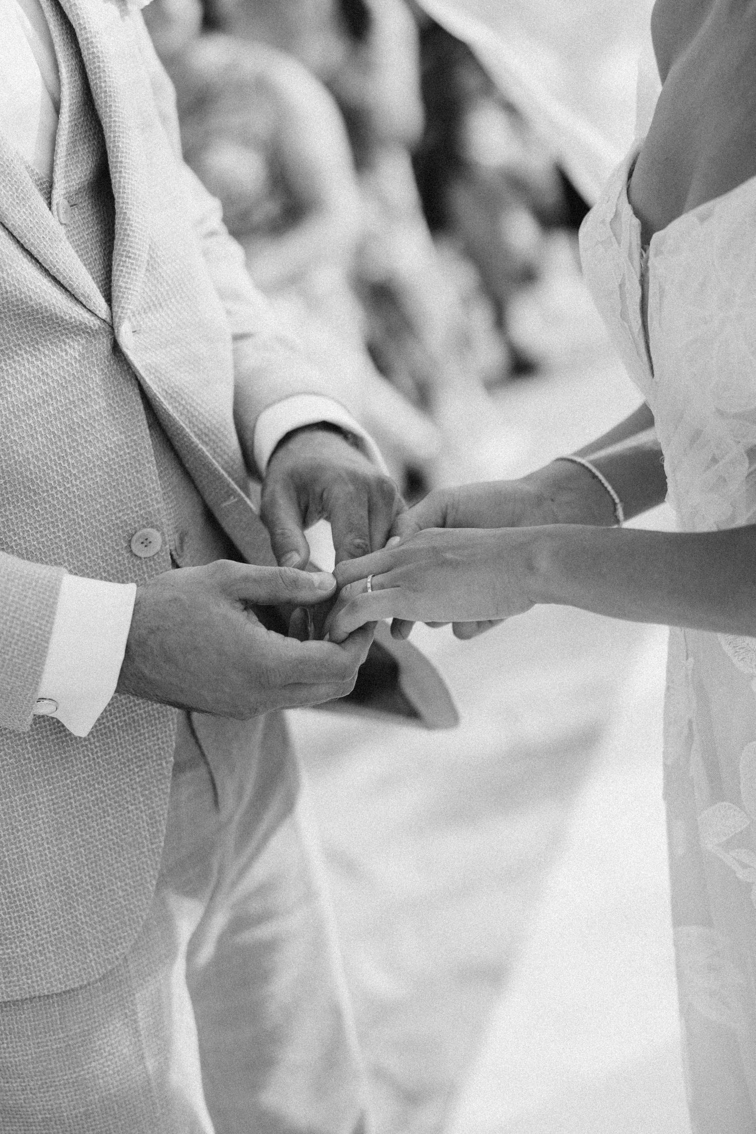 Close-up shots of hands exchanging rings during an intimate wedding ceremony.