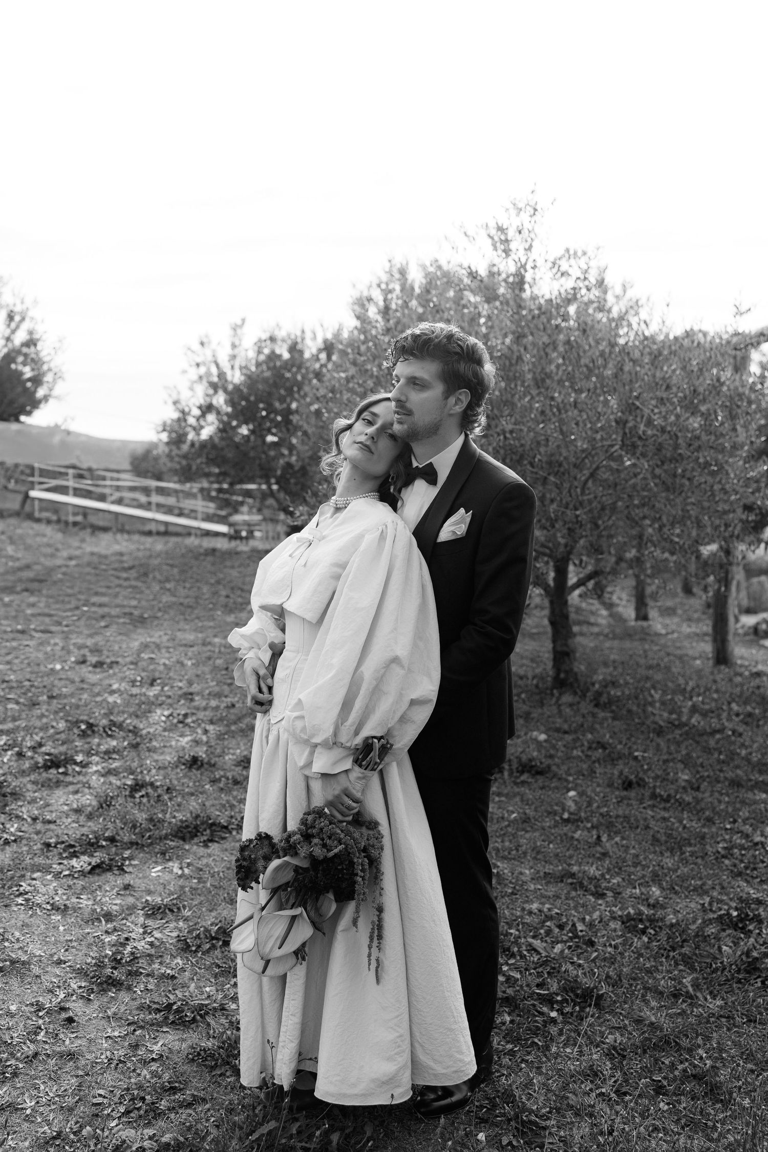 Black and white photos of a couple embracing in an orchard setting.