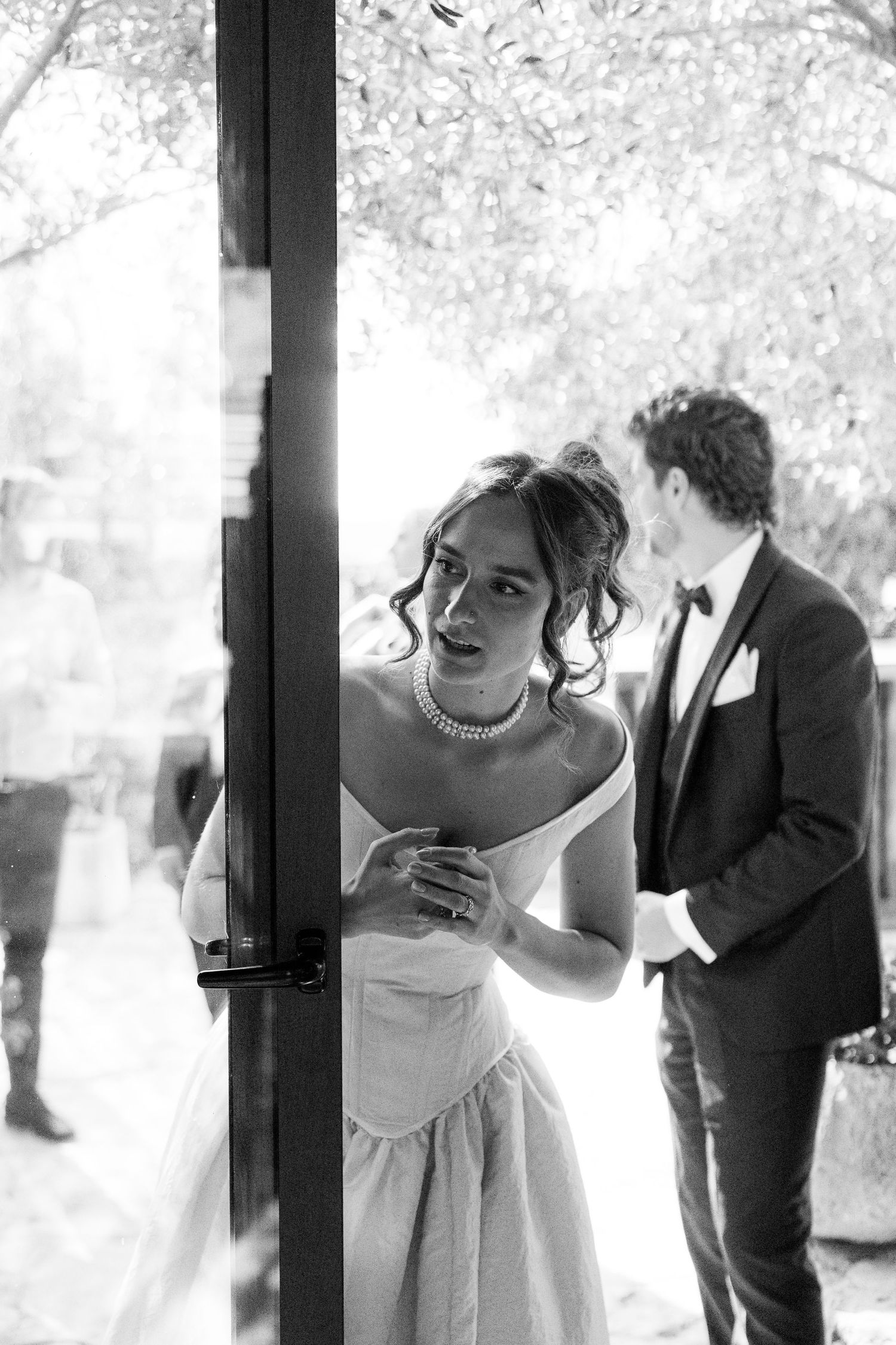 Black and white romantic wedding portrait showing intimate embrace against soft natural lighting.