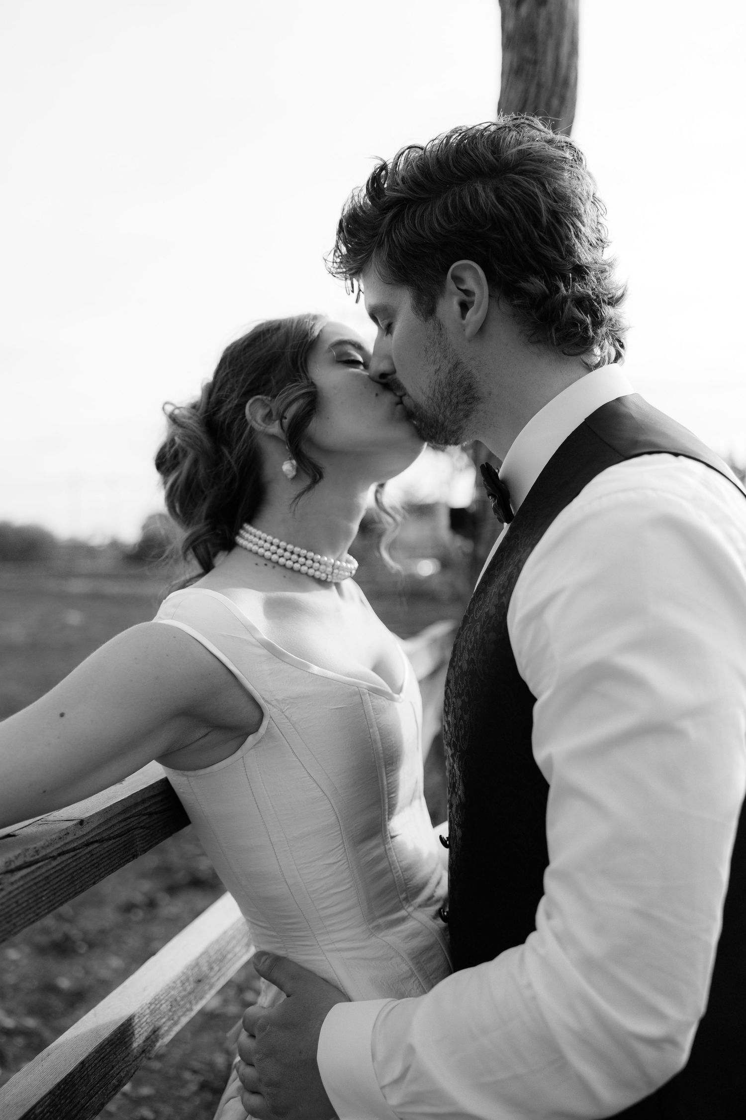 A romantic black and white photo sequence shows a couple in wedding attire embracing and sharing intimate moments outdoors.
