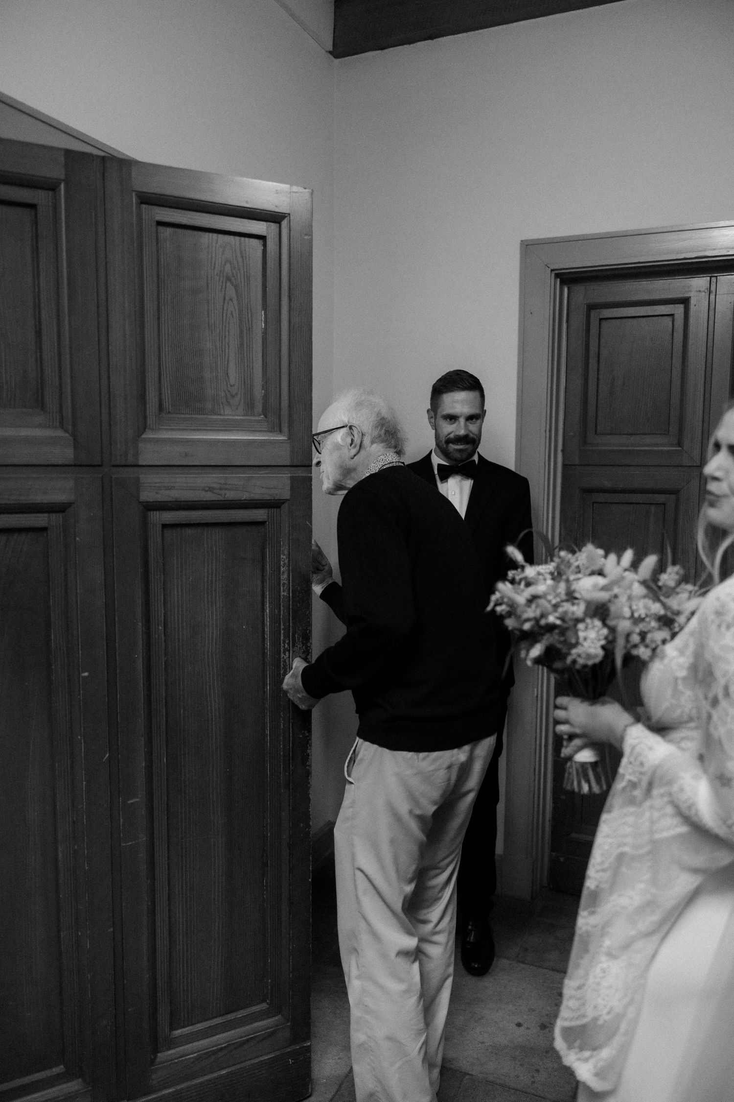 Black and white photo showing elegant wooden doors in a hallway.