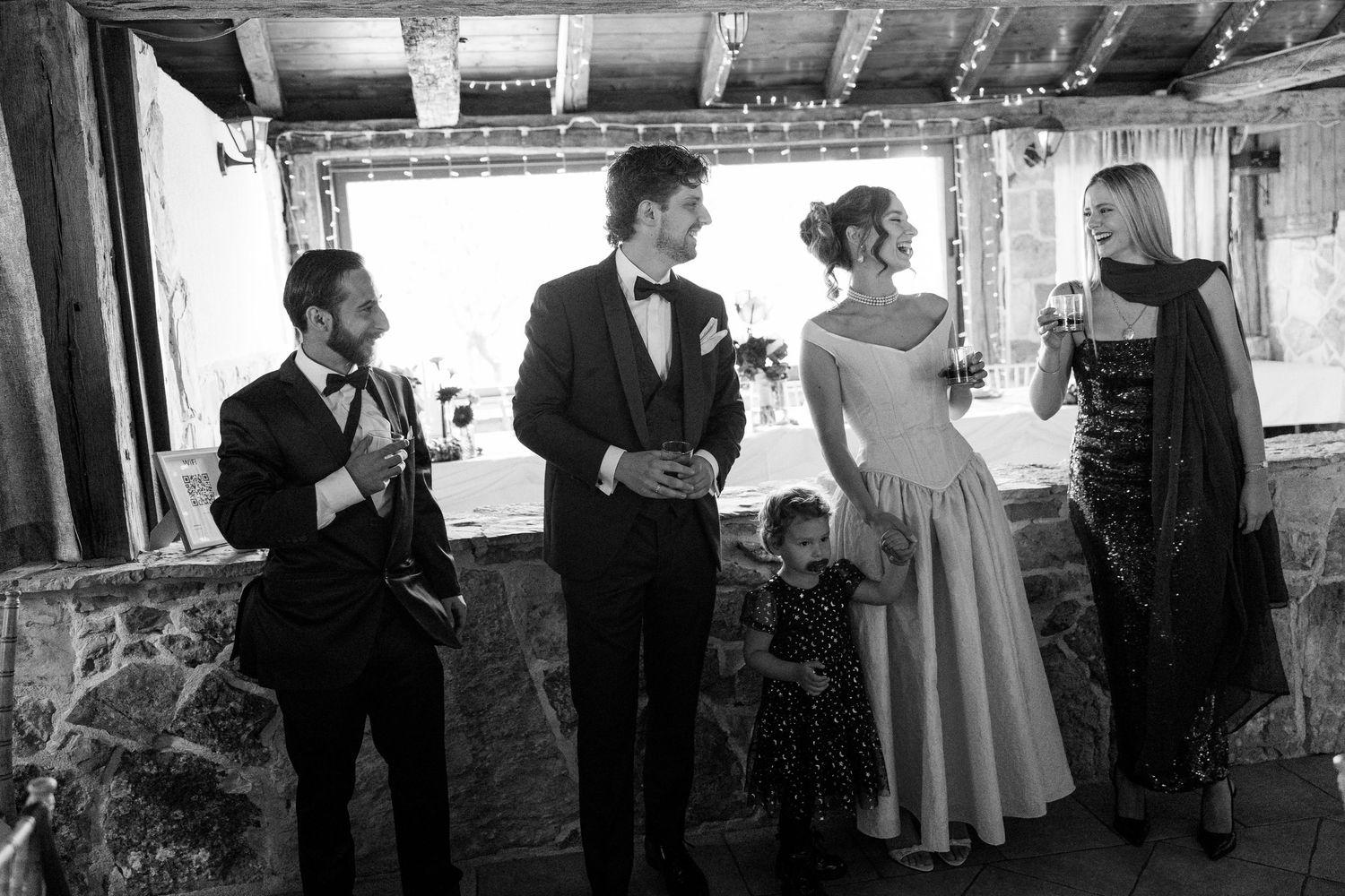 Black and white photo of guests mingling at an elegant indoor event.