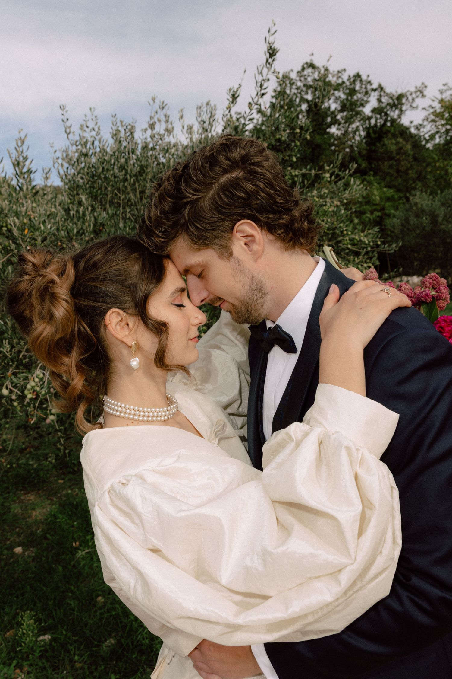 Romantic moment between couple against garden backdrop.