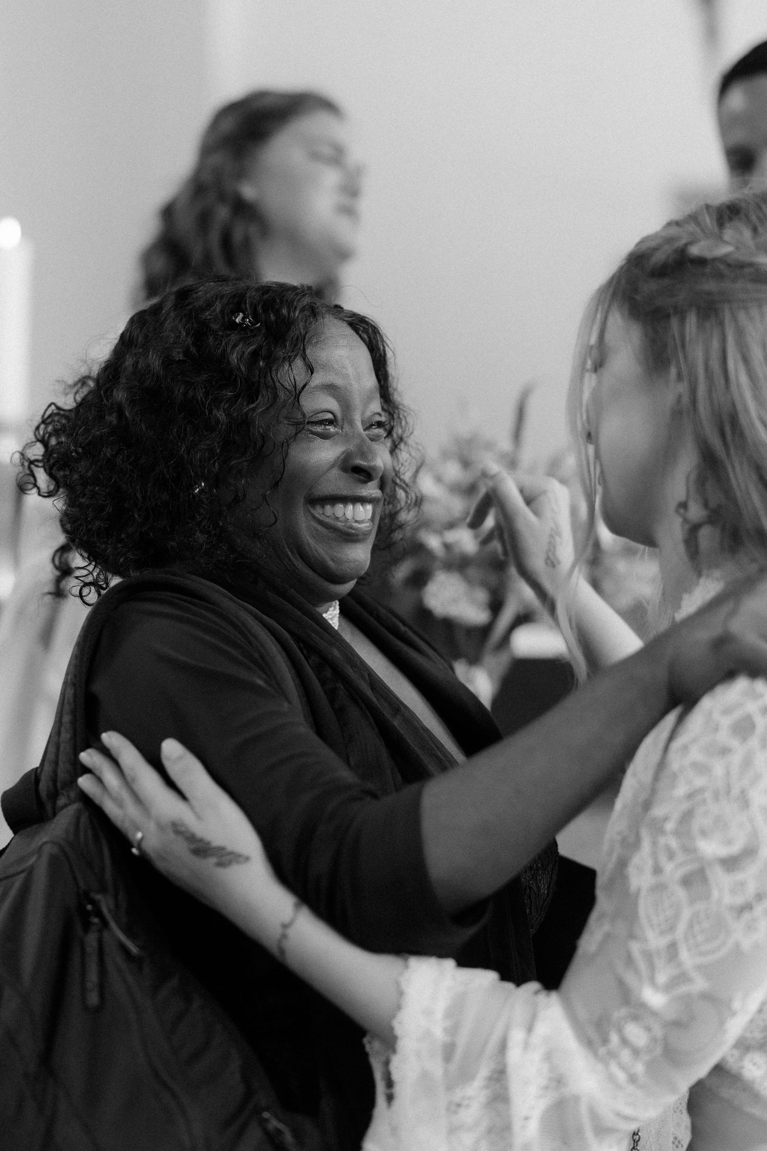 Wedding guests share warm embraces and celebratory moments during the reception.