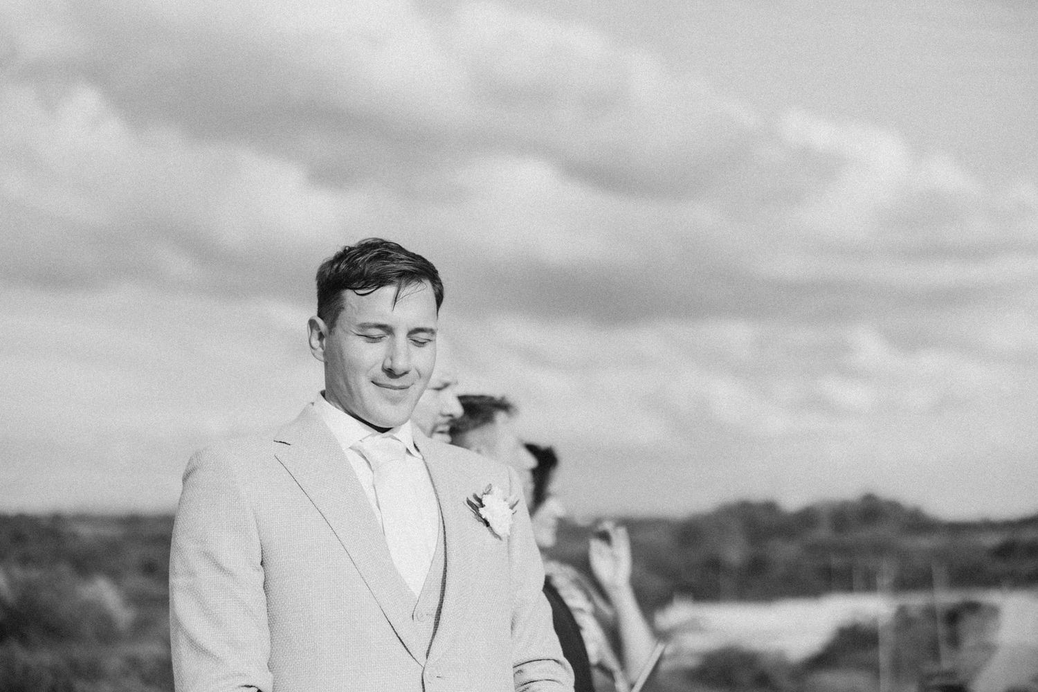 Outdoor vineyard celebration with formal attire and natural scenery.