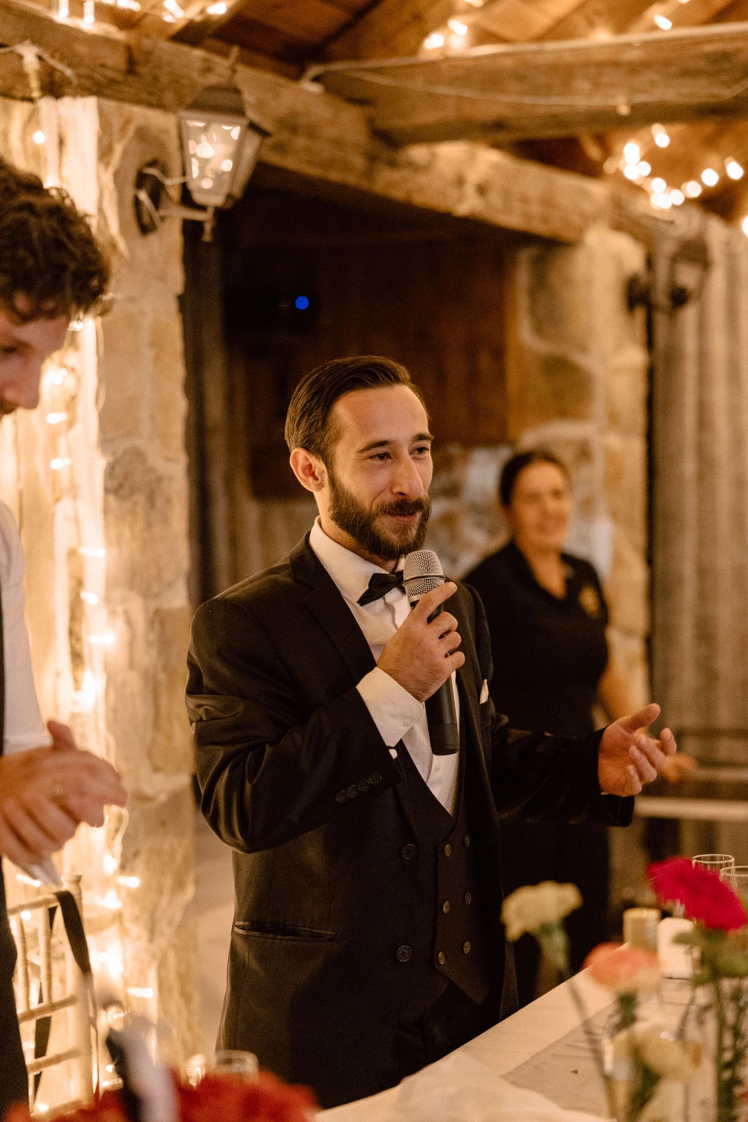 Warm candlelit reception venue with rustic stone walls and wooden beams.