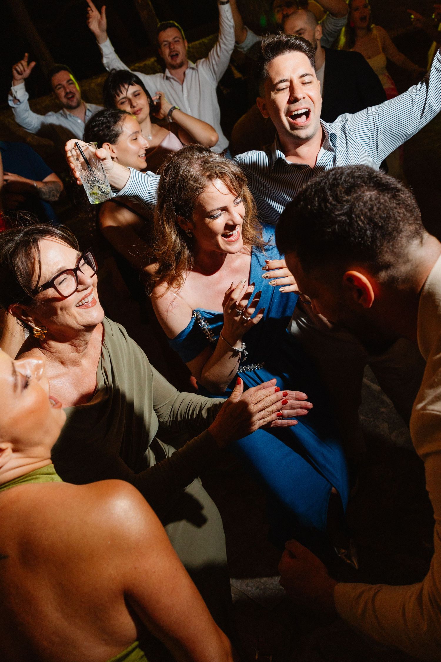 Energetic crowd dancing and celebrating at a lively indoor party event.