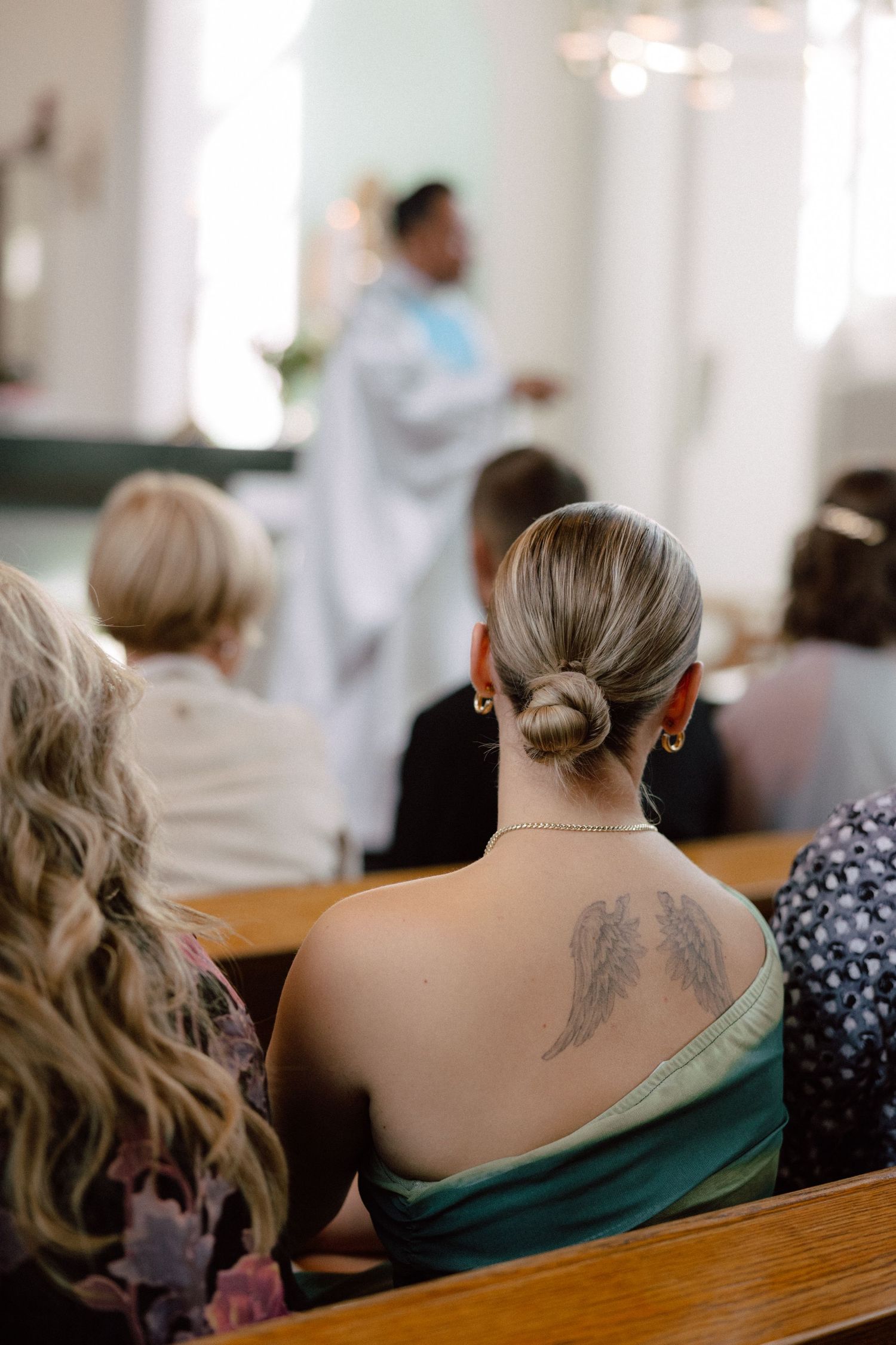 Church attendees with visible tattoos seated in wooden pews during service.