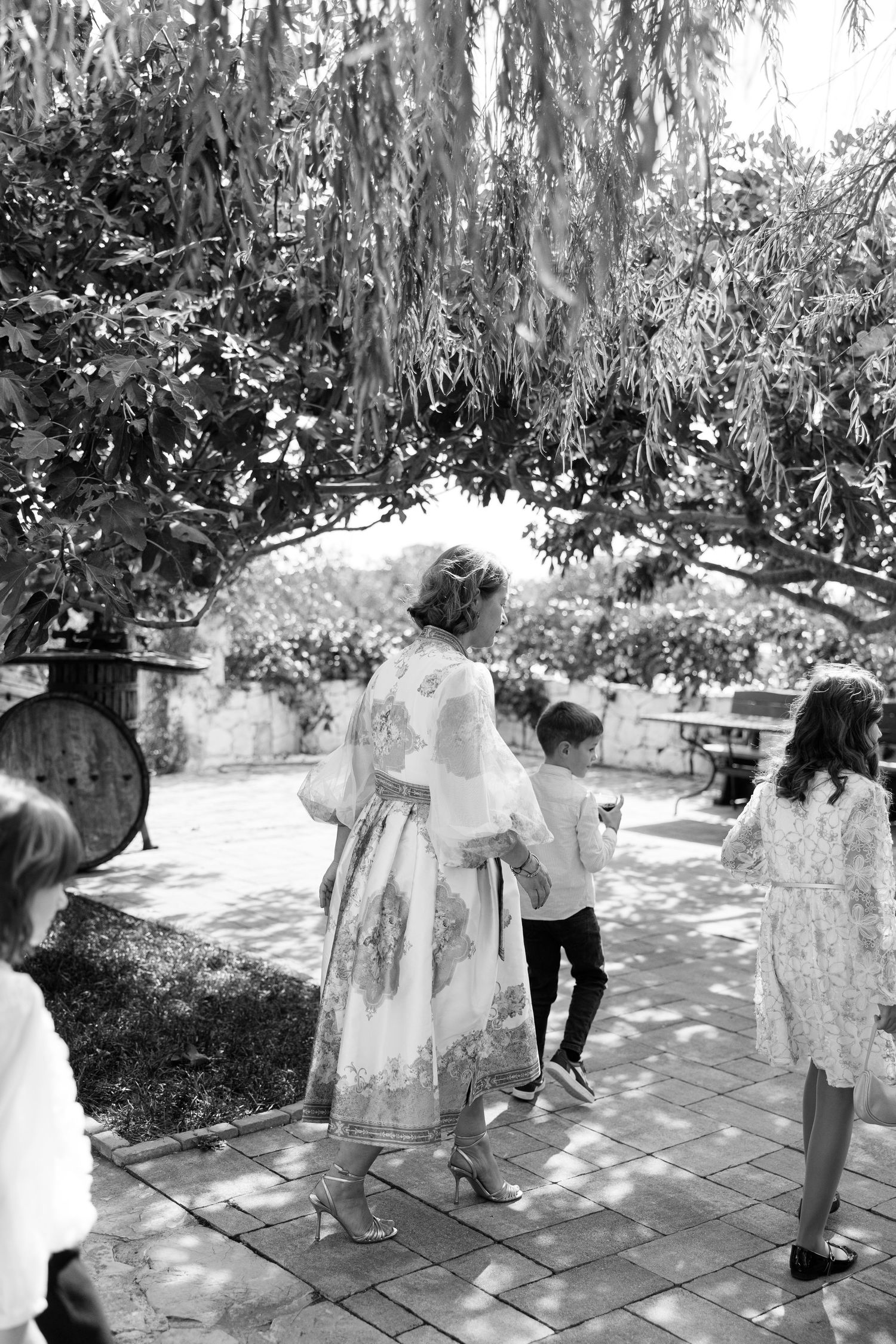 Black and white photos showing people walking around a garden path with stone features.