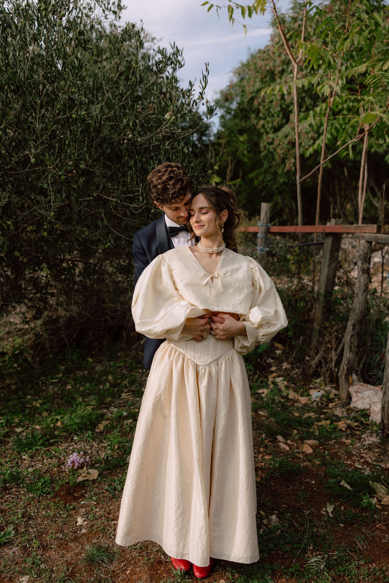Romantic wedding photos in garden setting with couple in formal attire sharing intimate moments.