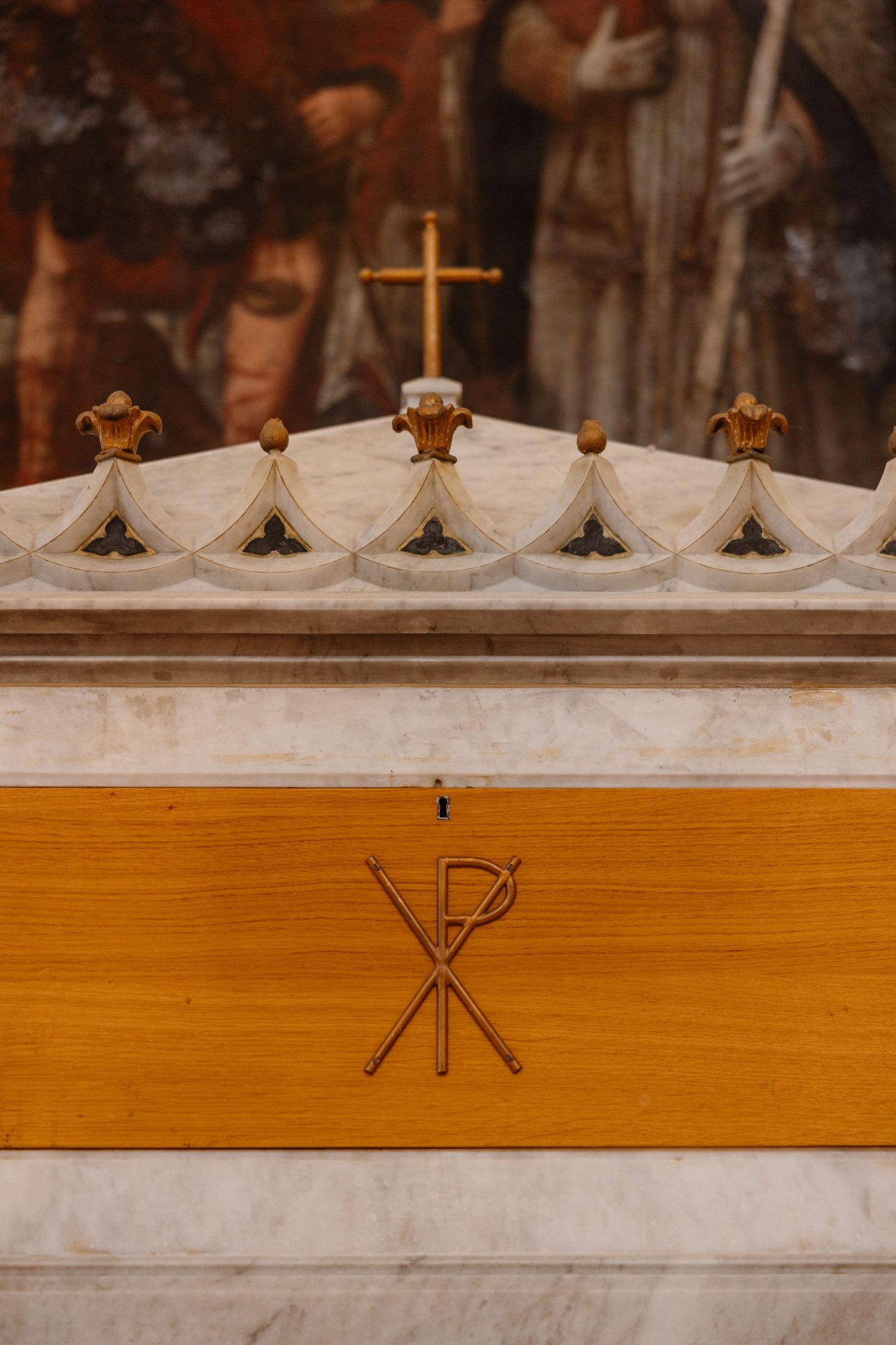 Decorative wooden church pew detail with ornate crosses and religious symbols.