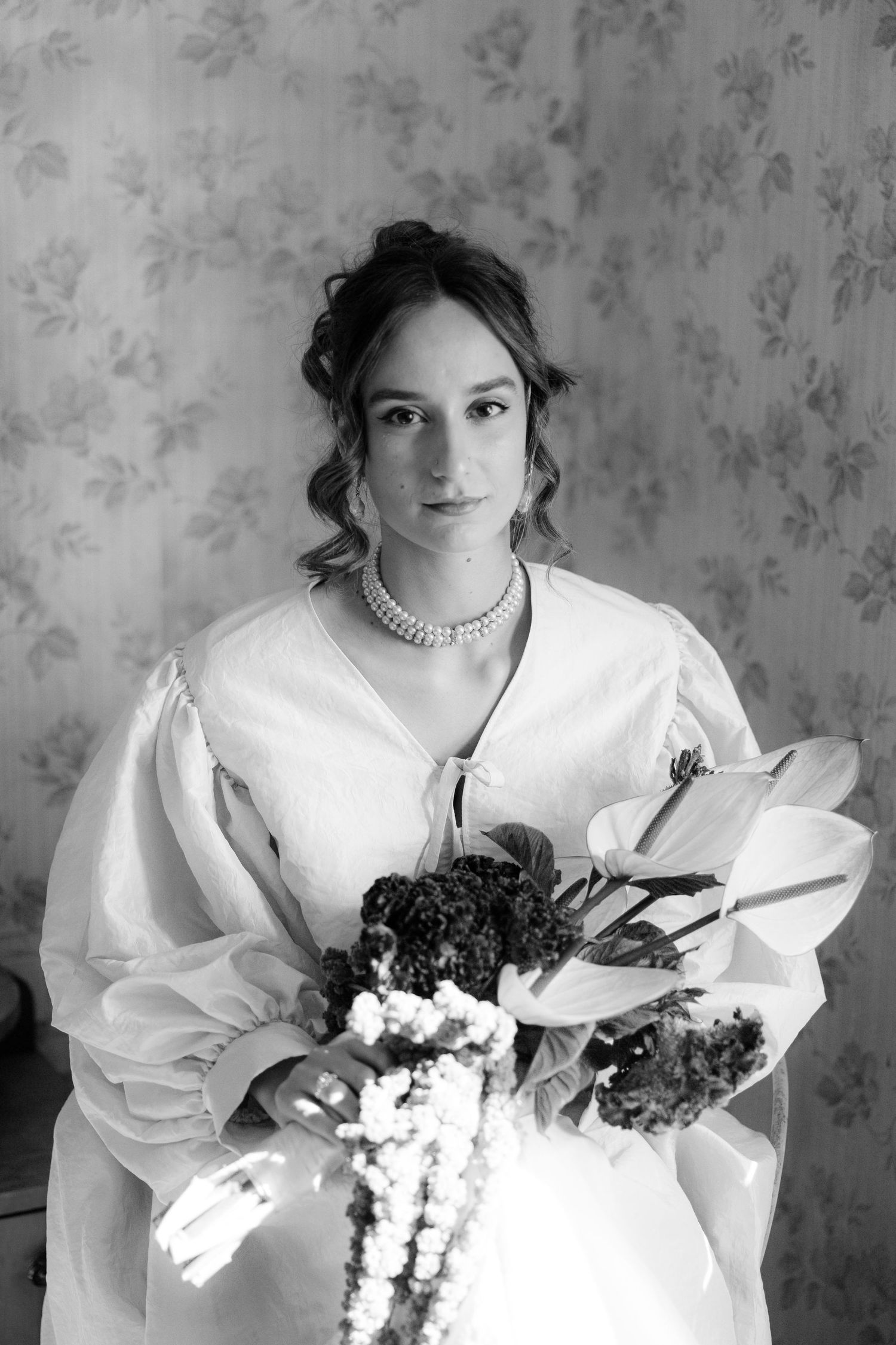 Bride in white dress with puff sleeves holding a bouquet in a series of artistic black and white portraits.