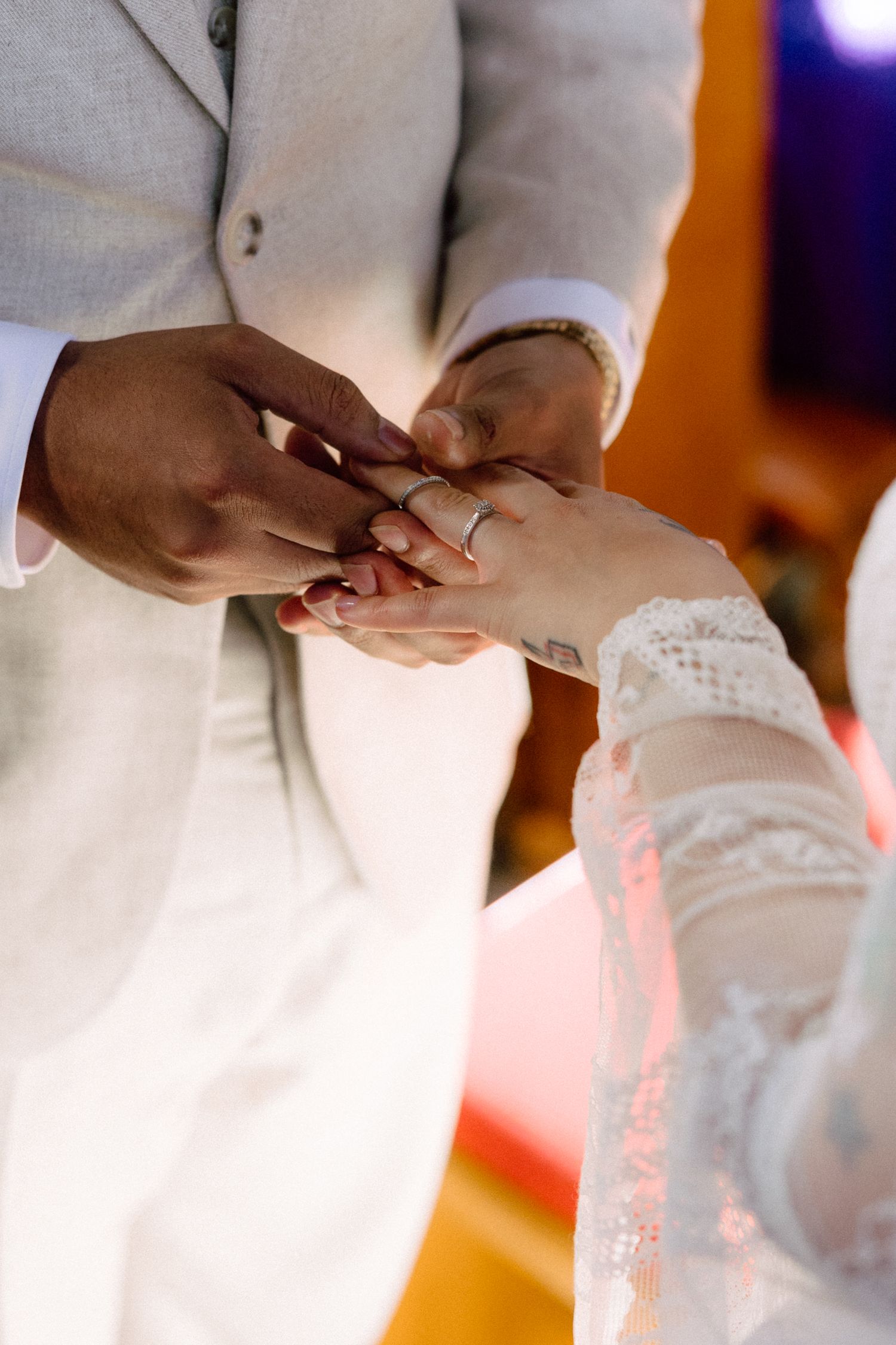 Close-up of couple's hands during ring exchange at wedding ceremony.