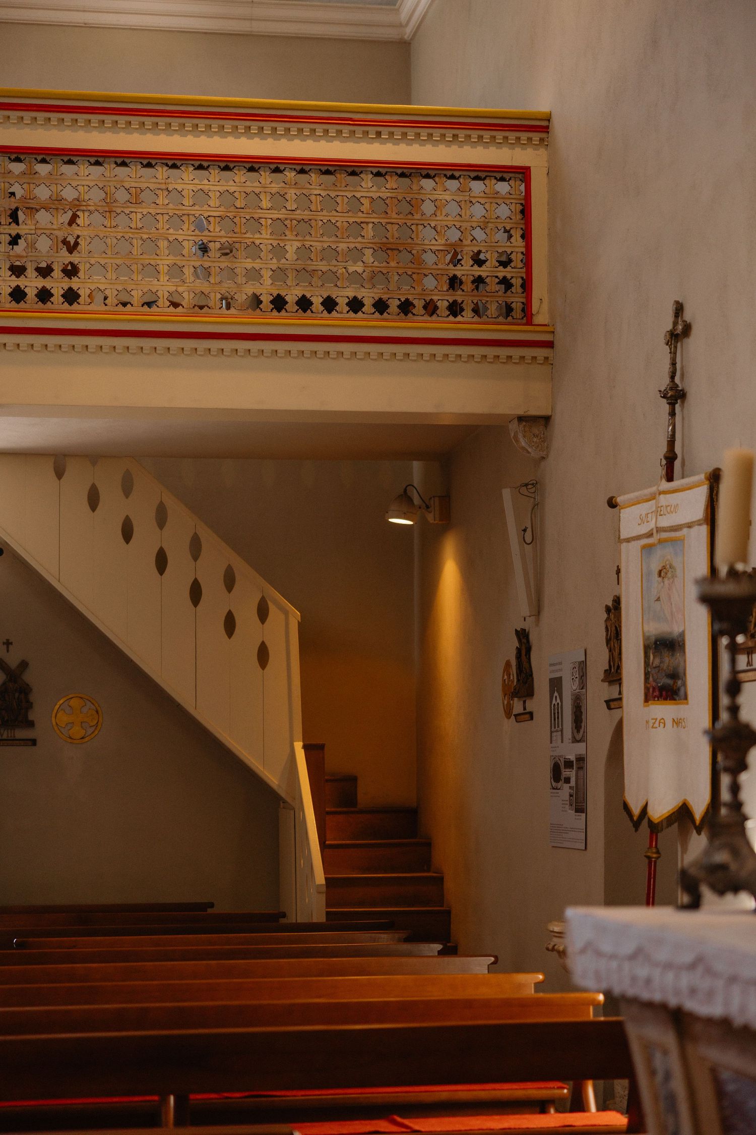 Interior view of an empty church sanctuary with wooden pews and decorative border along the walls.