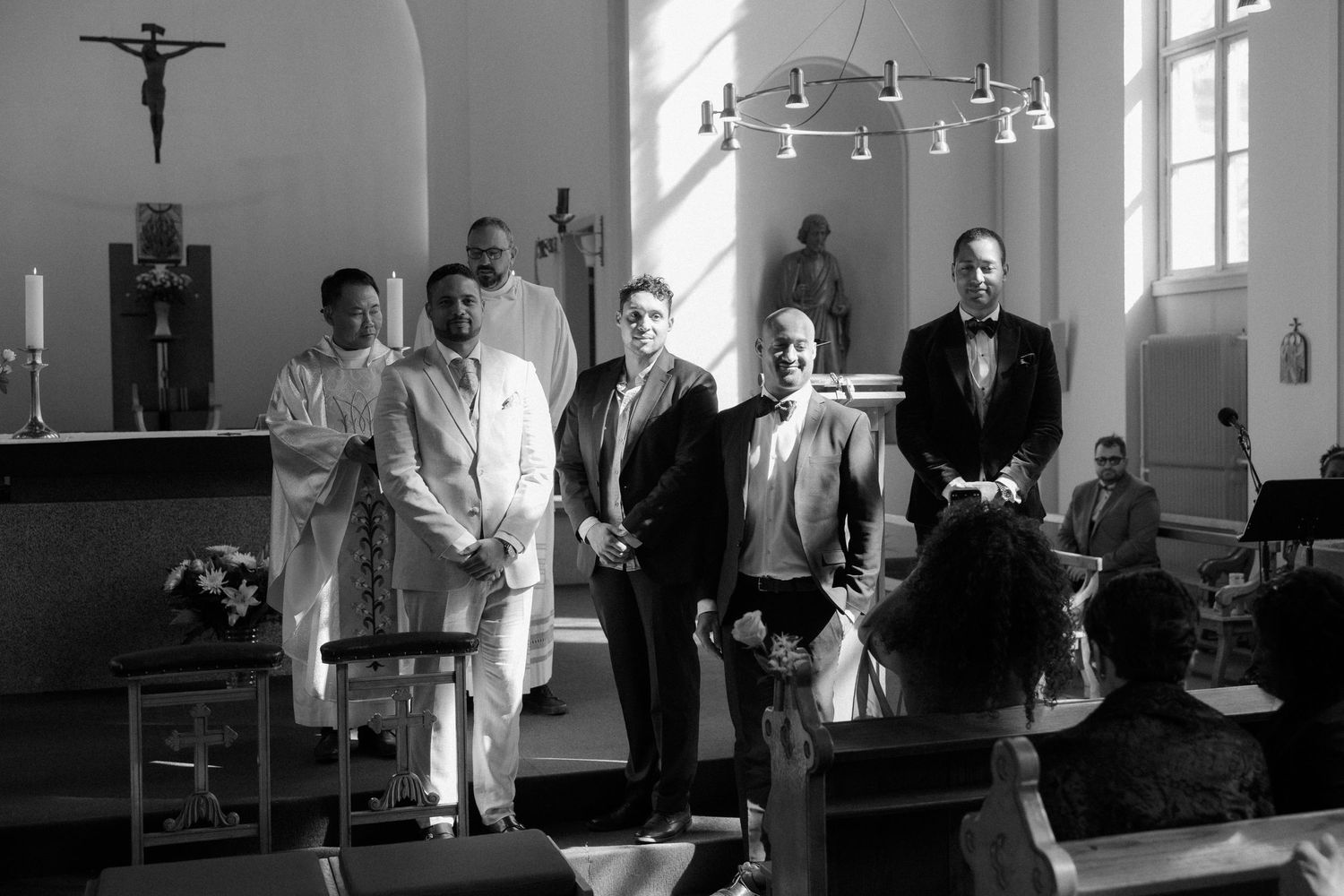 Interior of church sanctuary with crucifix and candles visible during wedding ceremony.