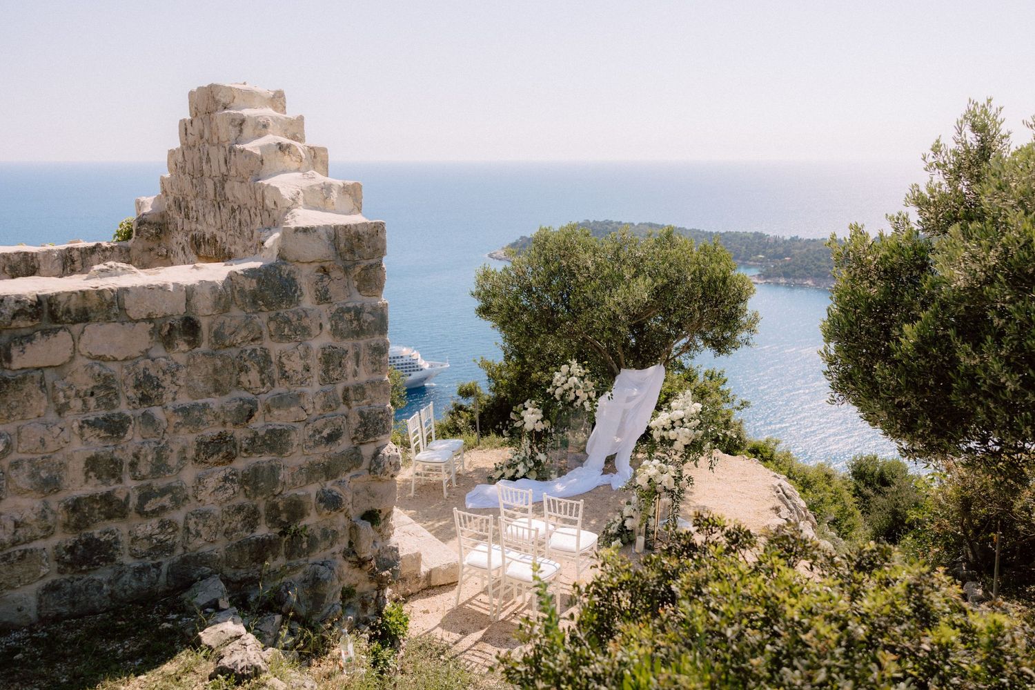 Mediterranean coastal landscape with stone buildings and blue sea views.