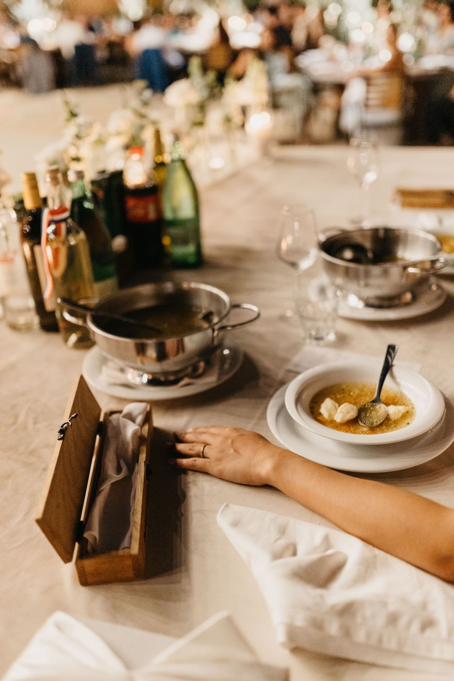 Elegant place settings with wine glasses and plates at a wedding reception table.