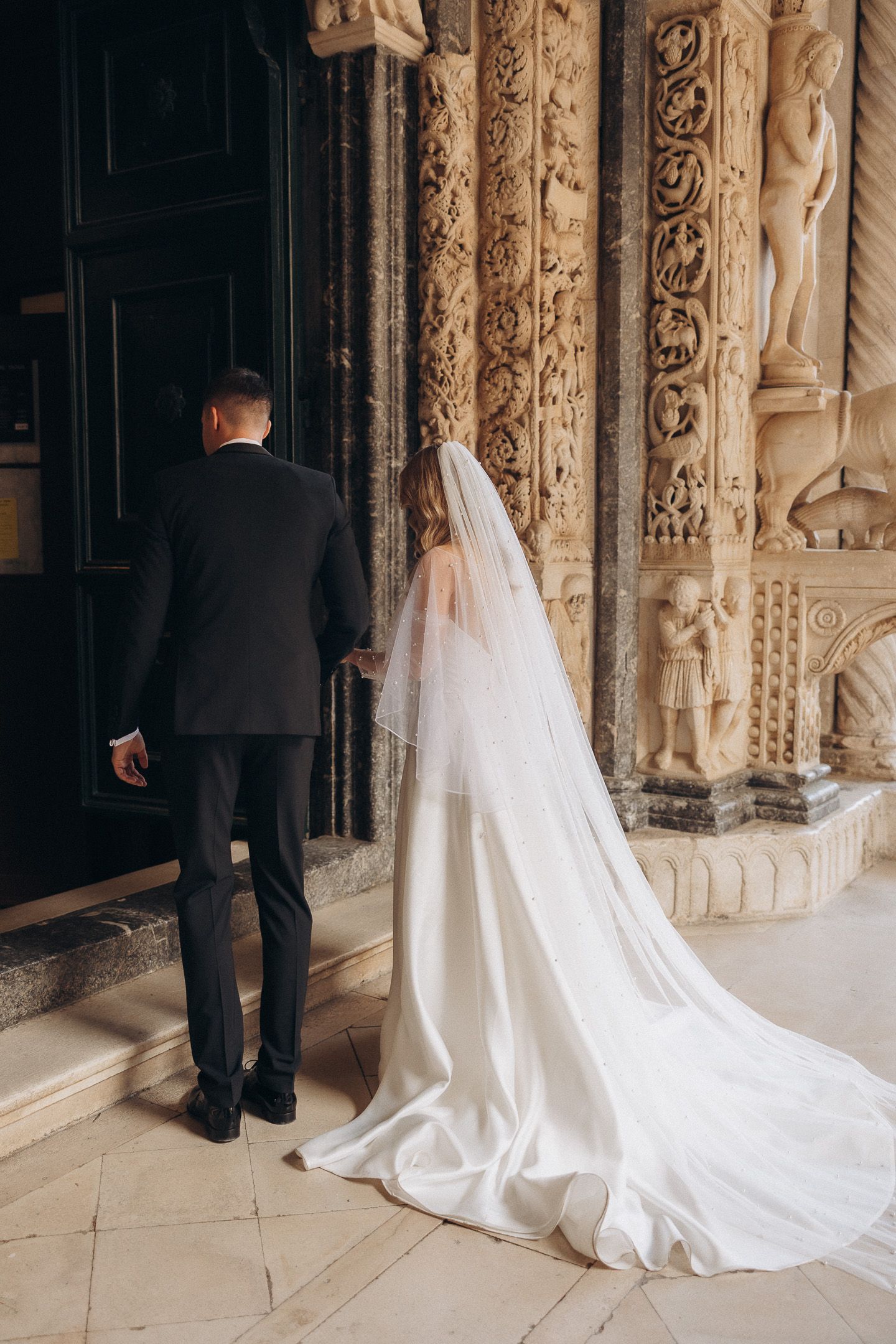 A series of wedding photos showing a long white bridal gown train trailing behind on ornate stone architecture.