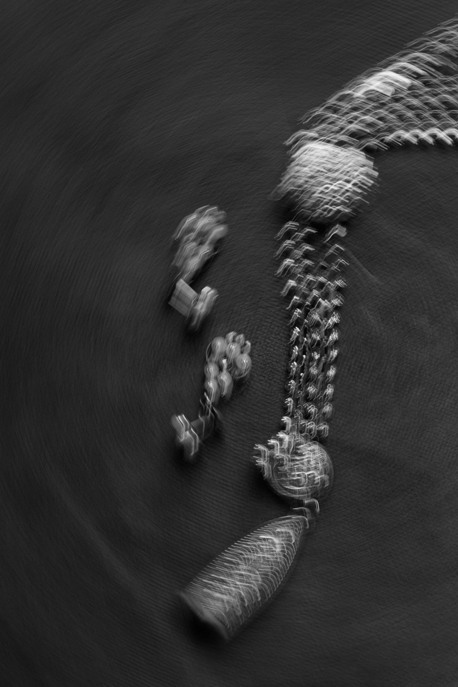 Abstract black and white motion blur photography creates a dynamic spiral pattern in low light.
