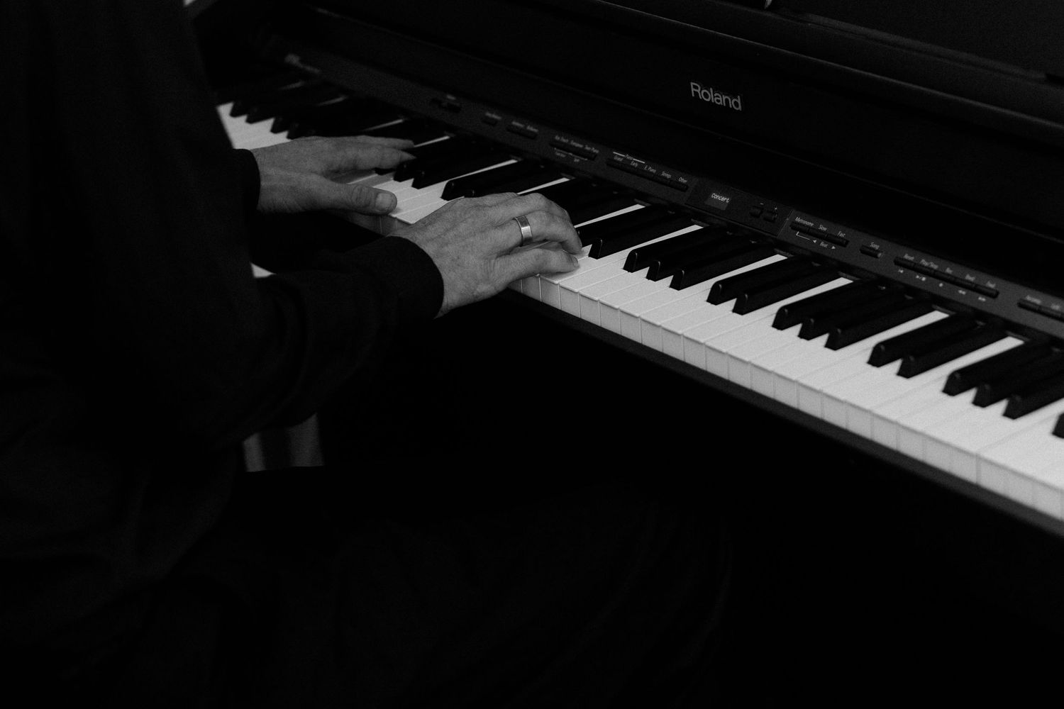 Close-up view of piano keys in dramatic black and white lighting.