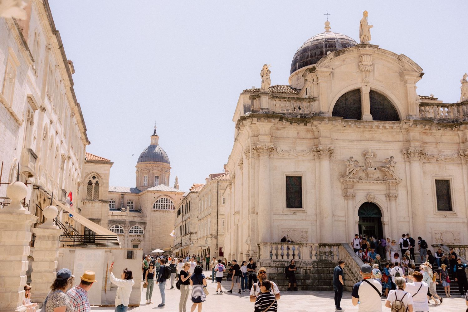 Panoramic view of a historic church exterior with domed architecture and stone walls  in Dubrovnik, Croatia.