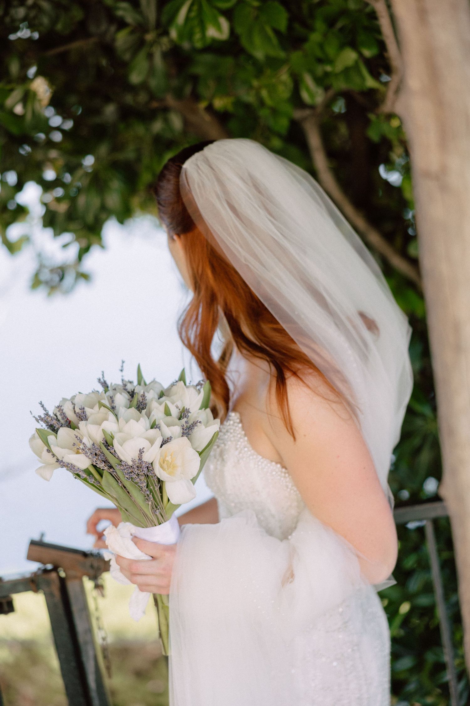 Delicate white and pink bridal bouquet with soft focus foliage background.
