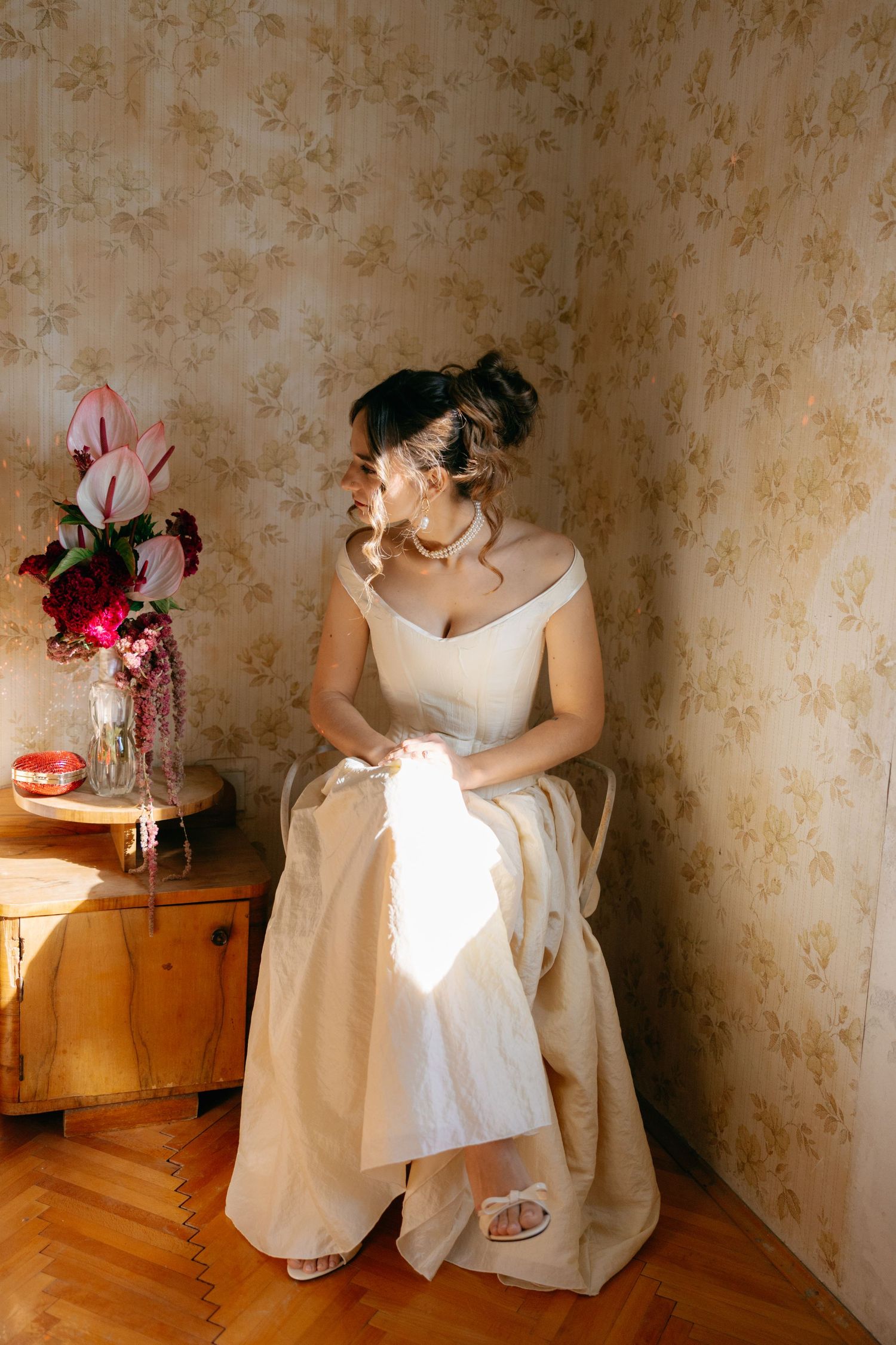 A series of artistic photographs showing a white dress against floral wallpaper with soft lighting and vintage decor.