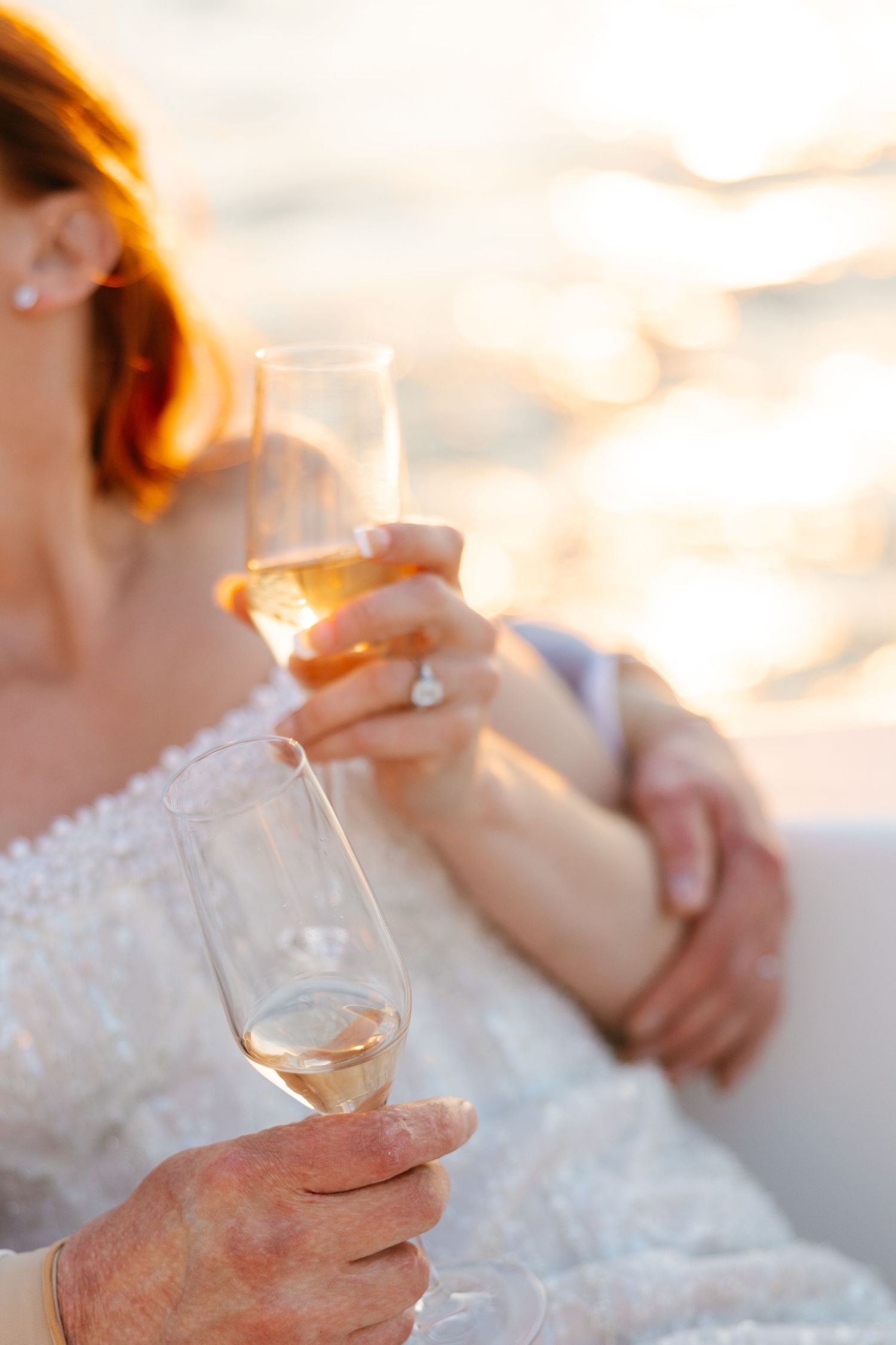Elegant wedding setting with champagne glasses catching golden sunset light.