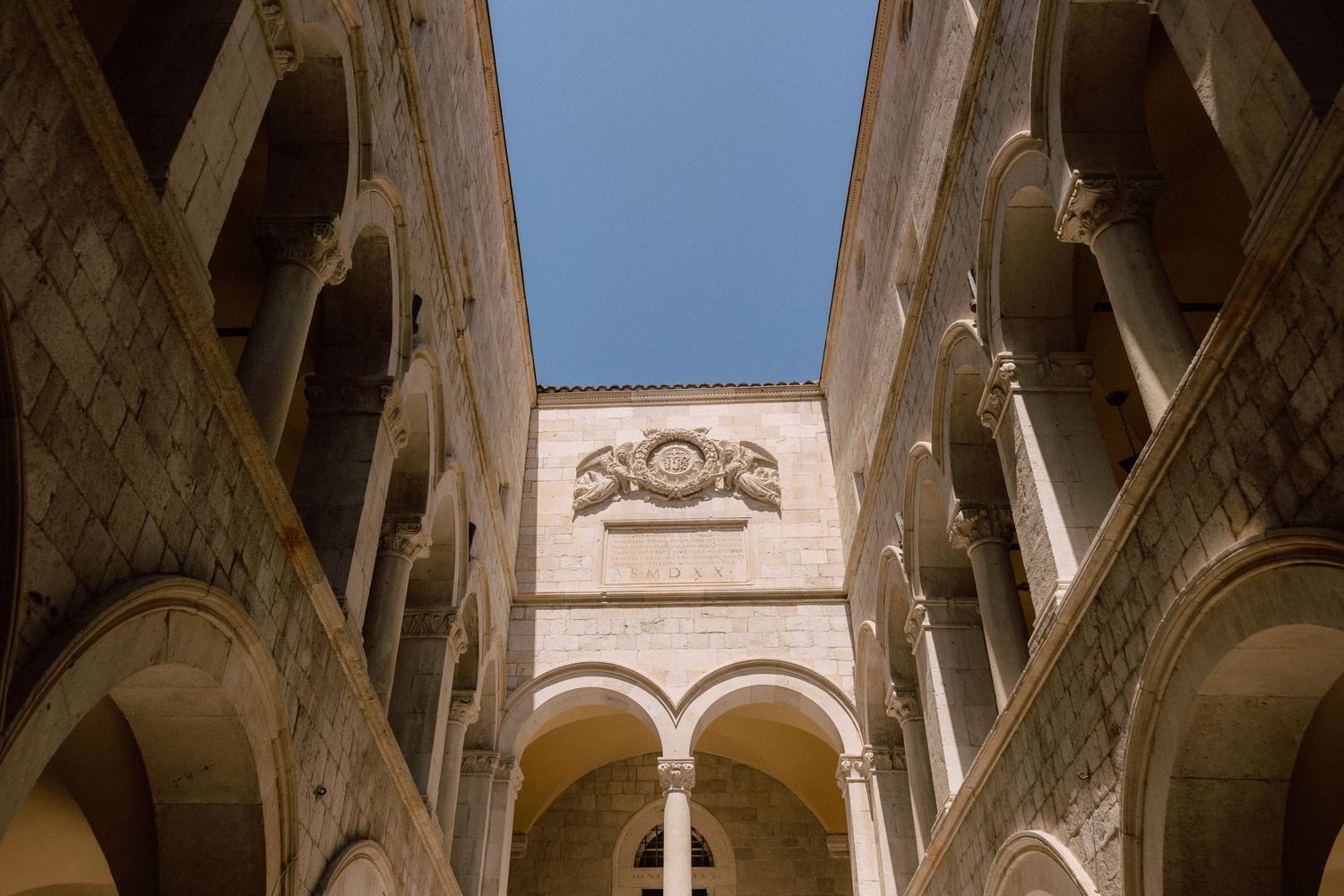 Stone archways and columns in a historic Mediterranean building interior  in Dubrovnik, Croatia.