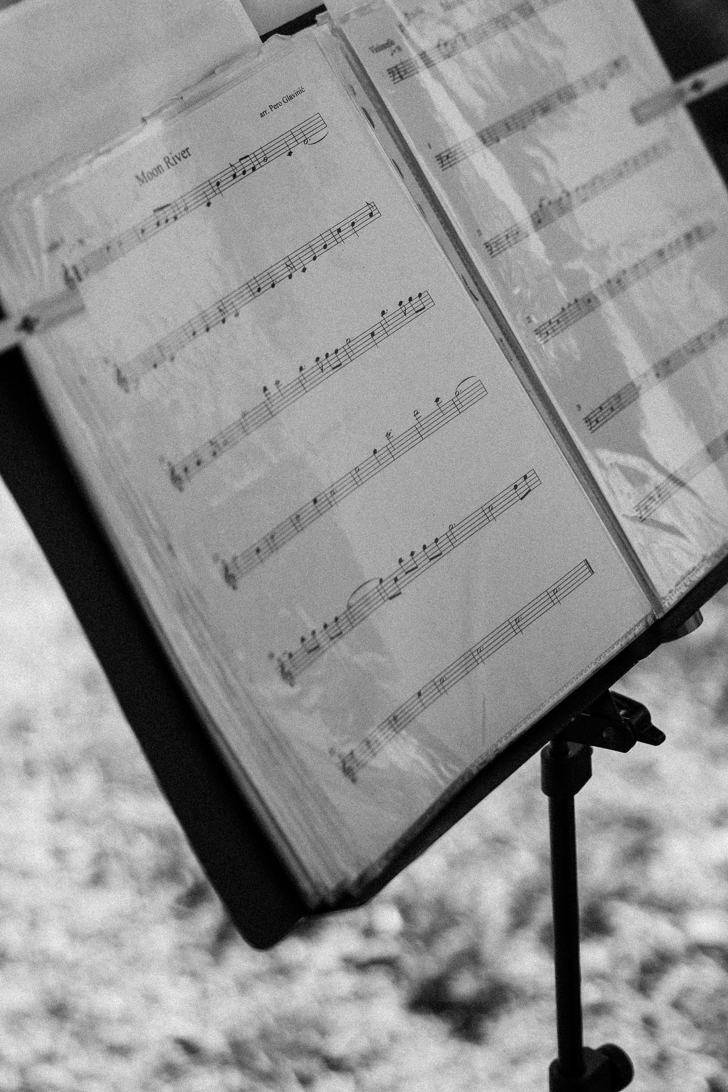 Black and white close-up of sheet music on a music stand.