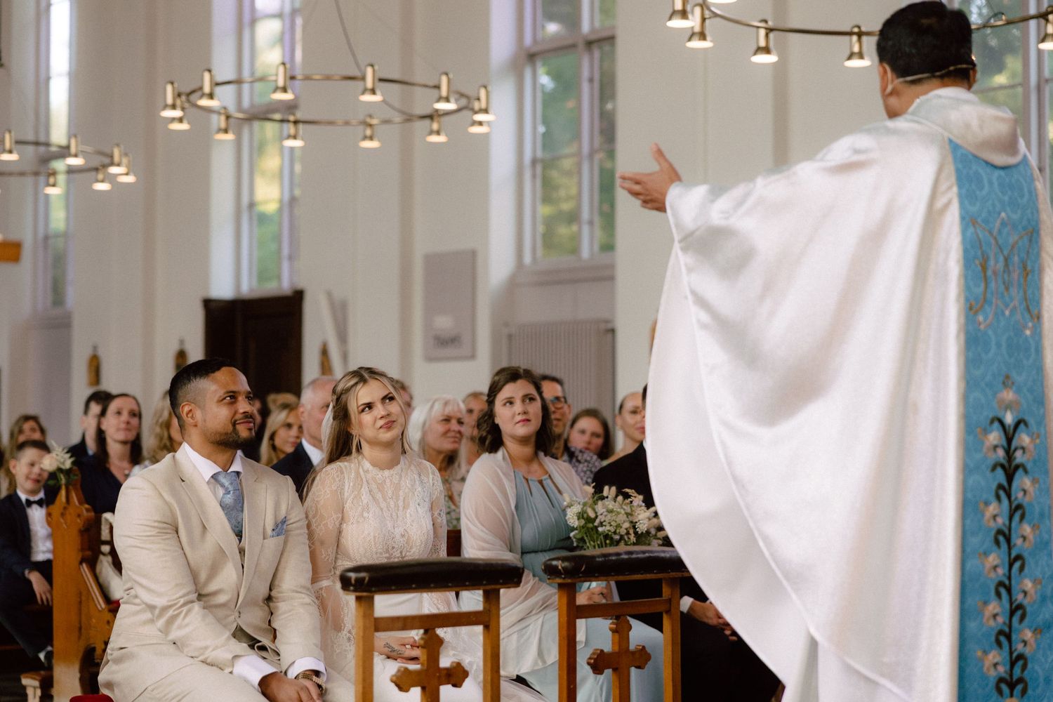 Church ceremony with overhead lighting and decorative elements.