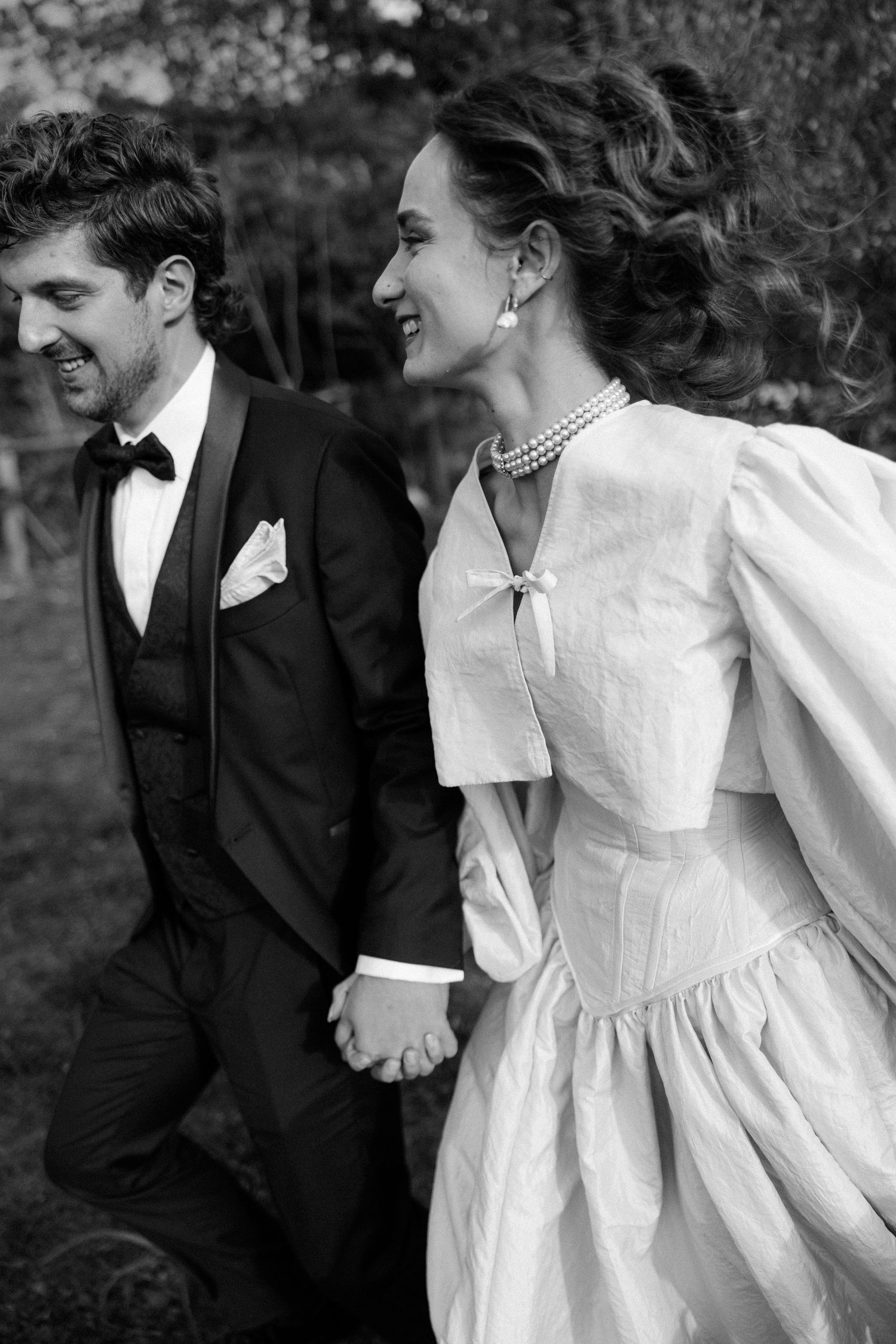 Black and white portrait of newlyweds walking together outdoors.