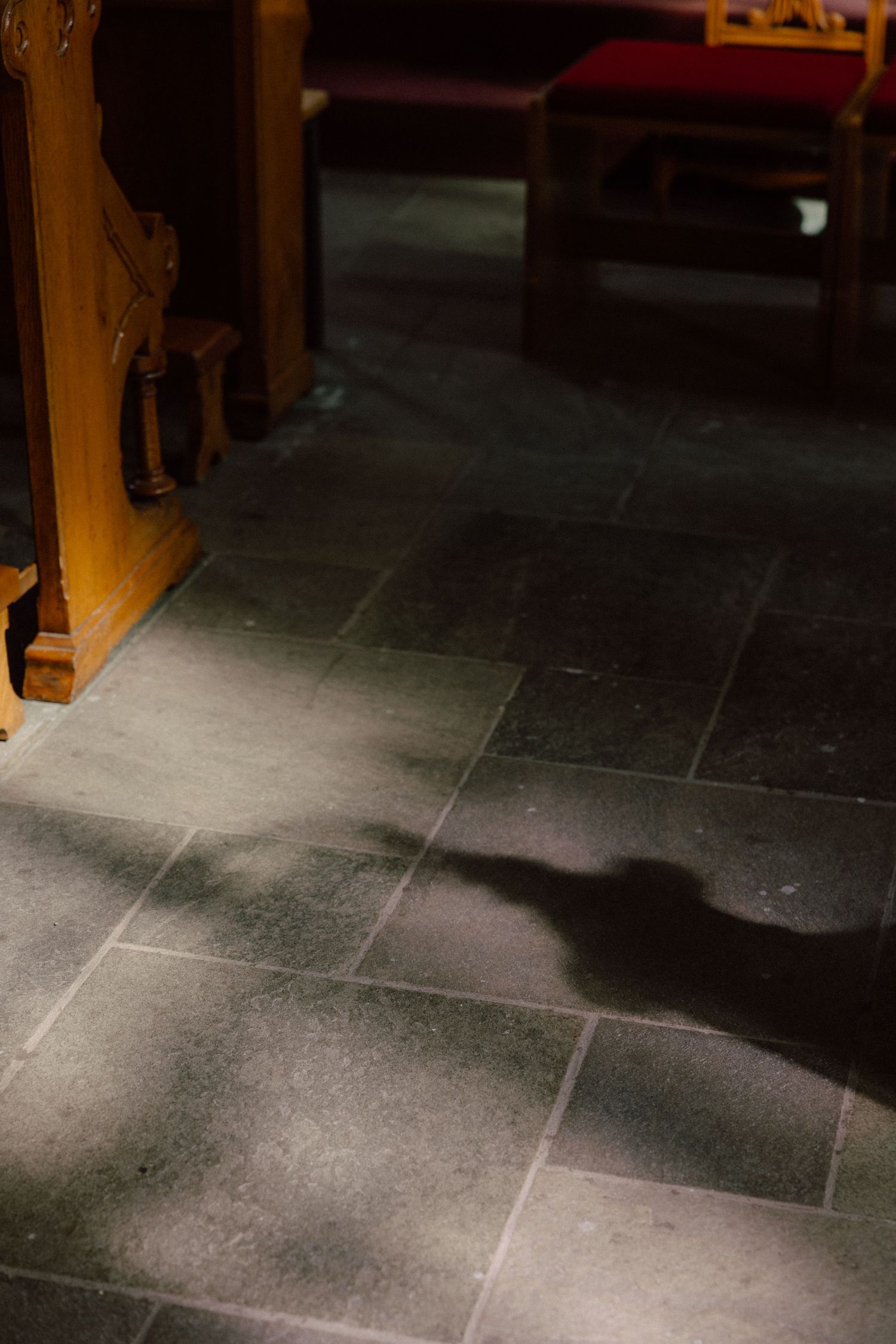 Dark stone floor tiles lit by dramatic shadows and lighting.