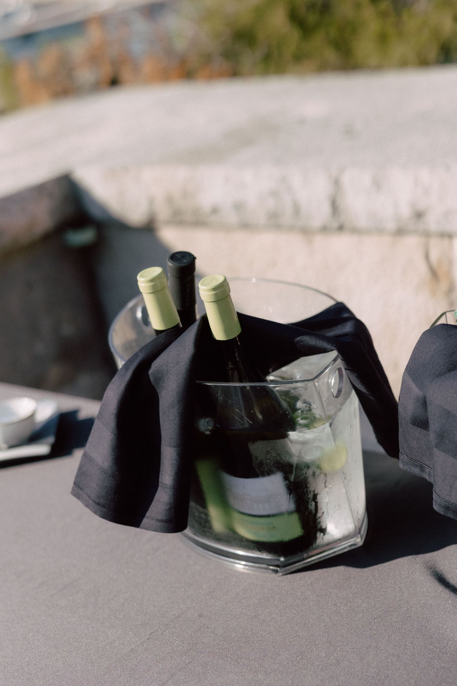 Black fabric wraps and glass bottles arranged artistically on gray surface.