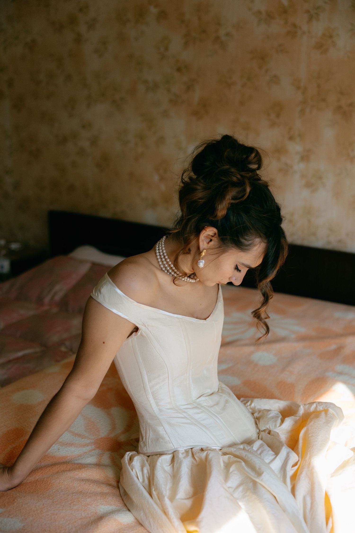 Artistic sequence of a person in white dress reclining on a bed in warm lighting.
