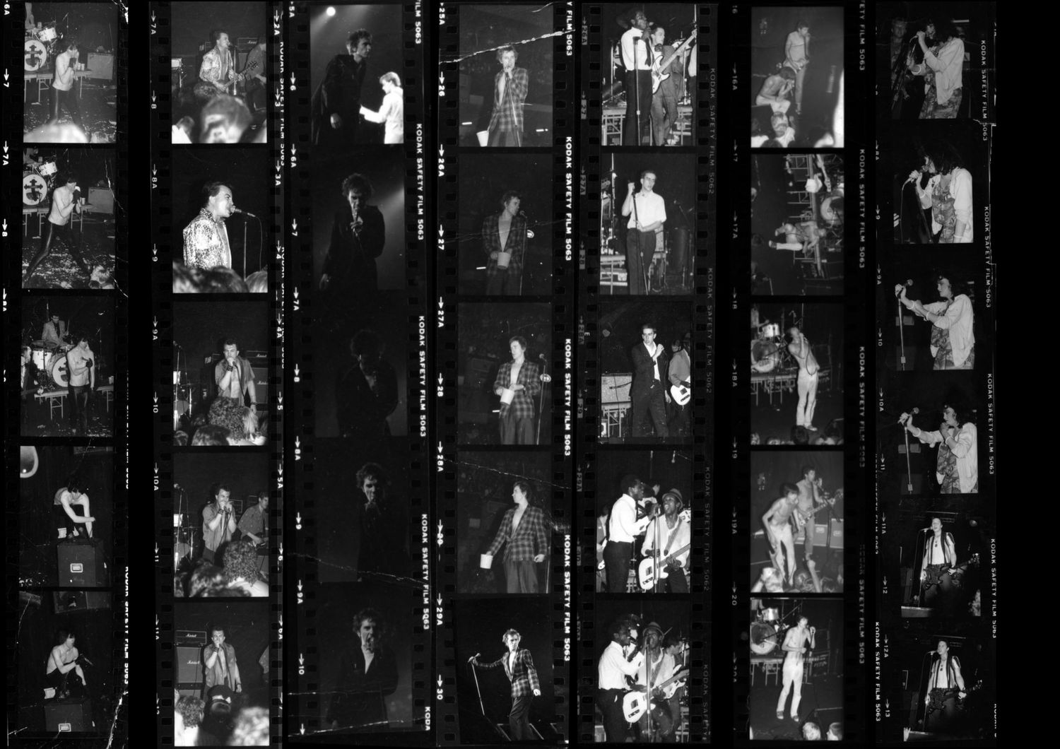 Contact sheet of black and white film negatives showing performers on stage during a musical performance.